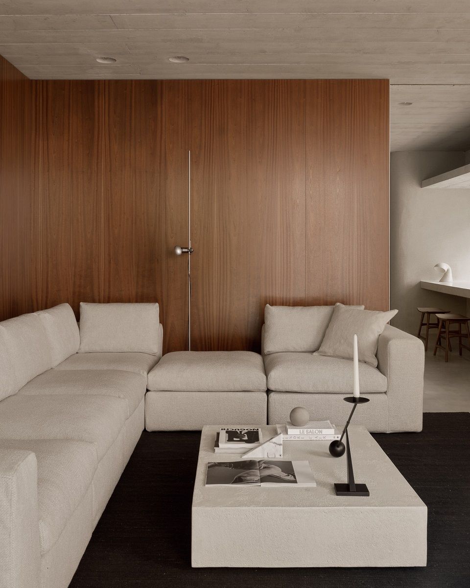 Moderner Wohnraum mit Ethnicraft Elements Couchtisch in Microcement Off White, rechteckig, und beiger Eckcouch.