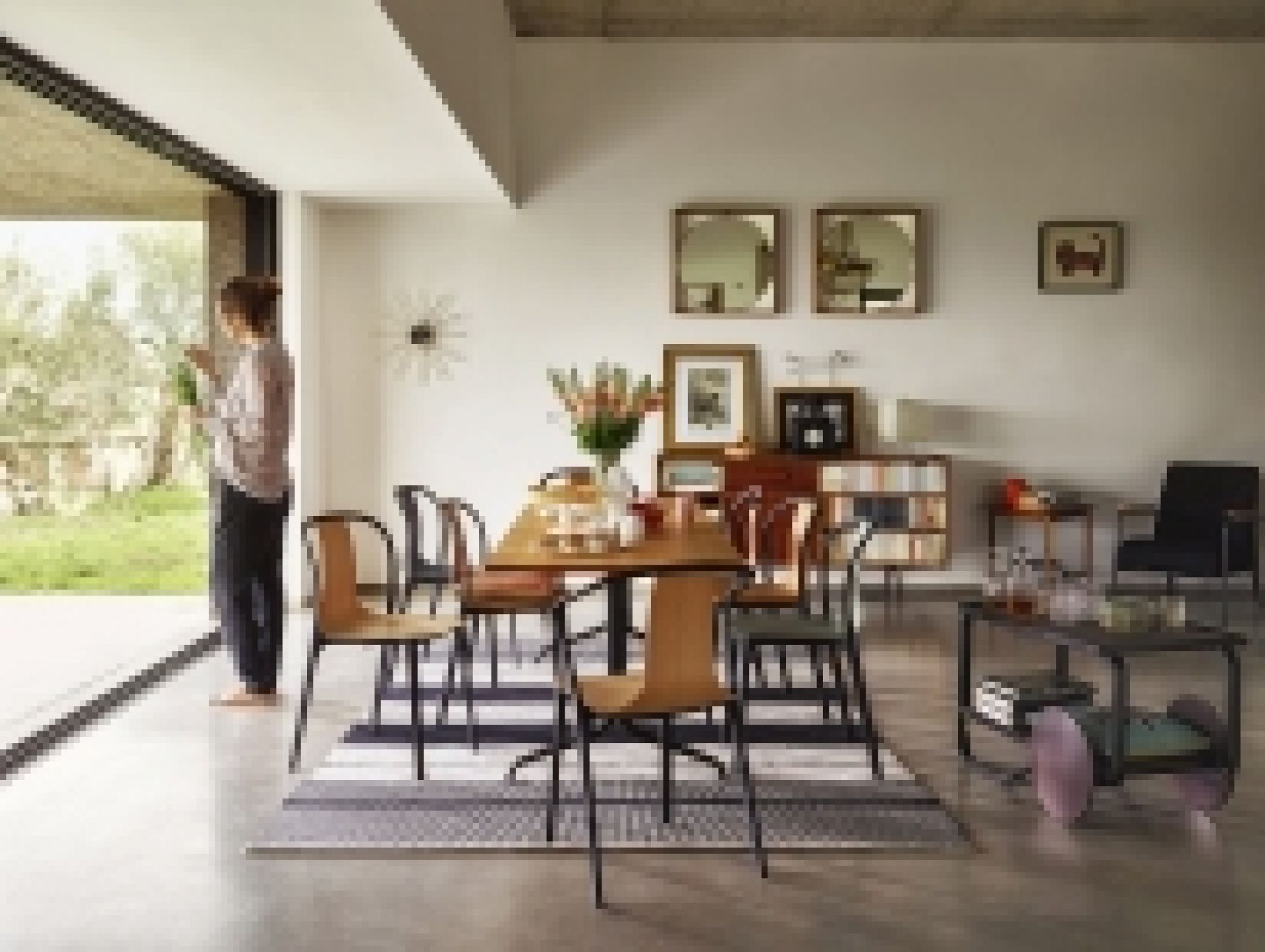 Esszimmer mit Vitra Belleville Table Tisch, Stühlen und Teppich auf Betonboden.