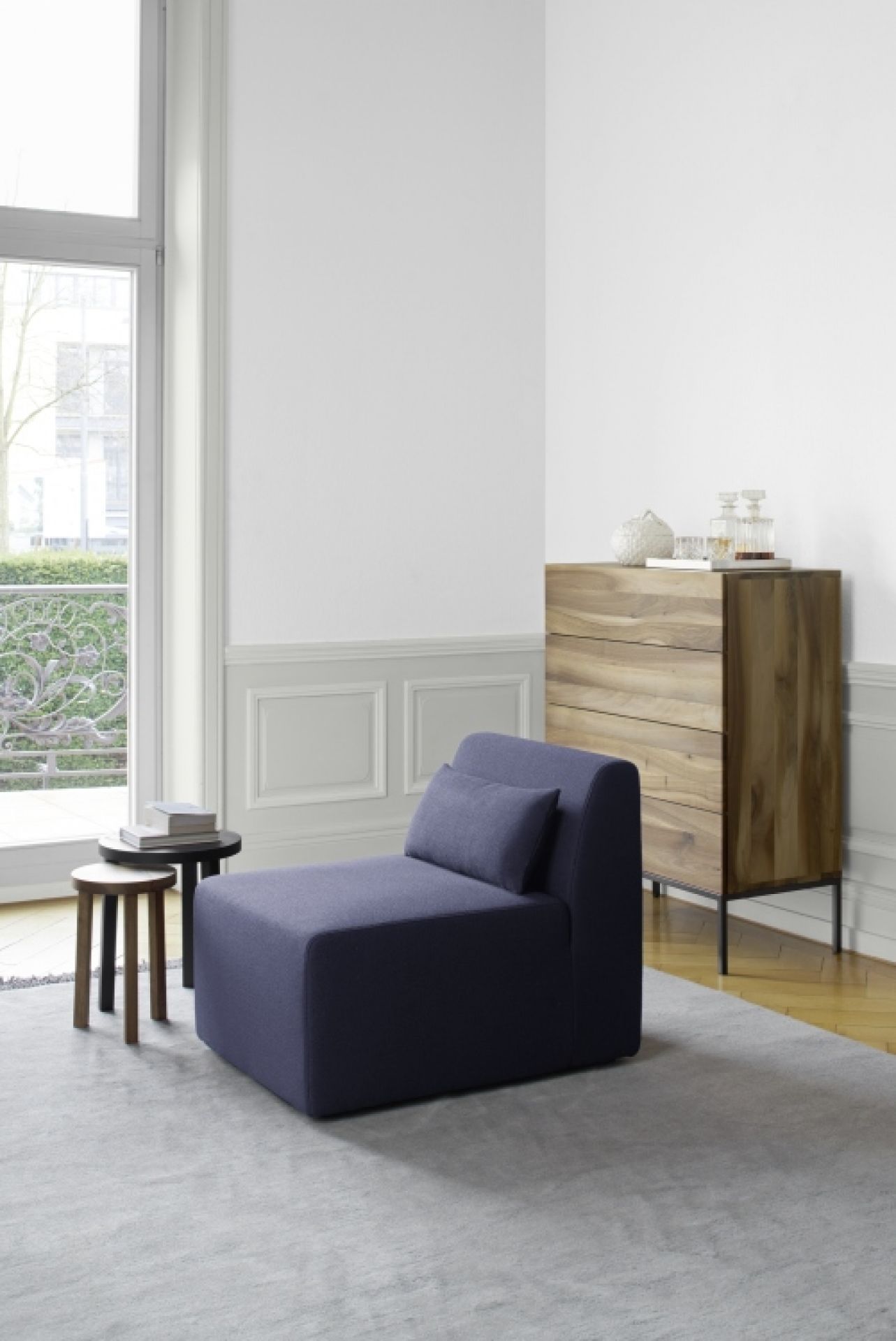 SF06 Kerman e15 Modulsofa in blau mit Kissen, Beistelltischen und Kommode im modernen Wohnzimmer.