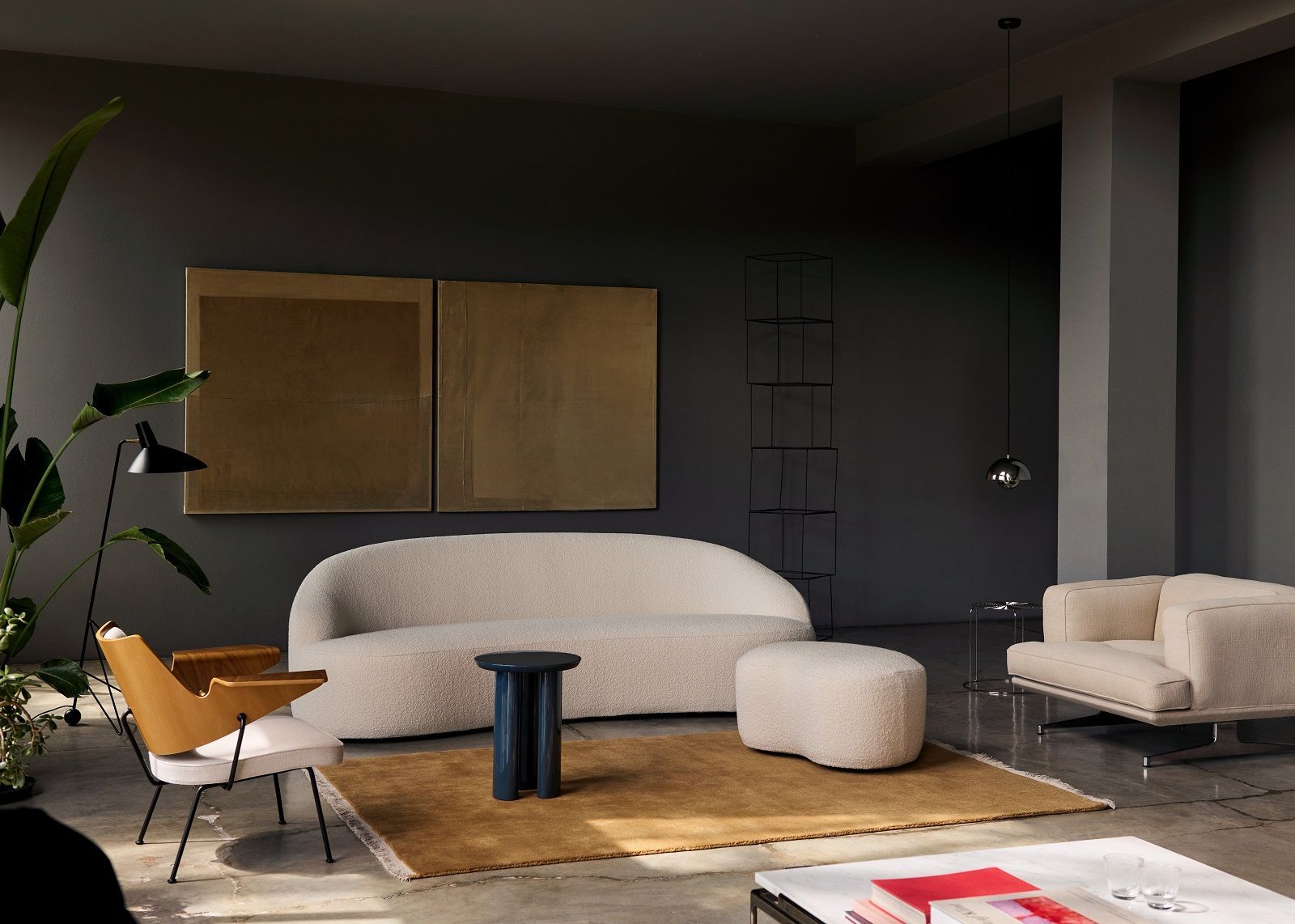 AndTradition Margas LC5 Pouf Hocker in Beige, Teil einer stilvollen Wohnzimmer-Szene mit Sofa.
