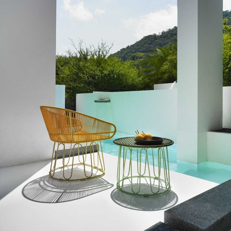 Honiggelber Circo Lounge Chair Outdoor Sessel neben Beistelltisch am Pool. Gartenmöbel für entspannte Stunden.