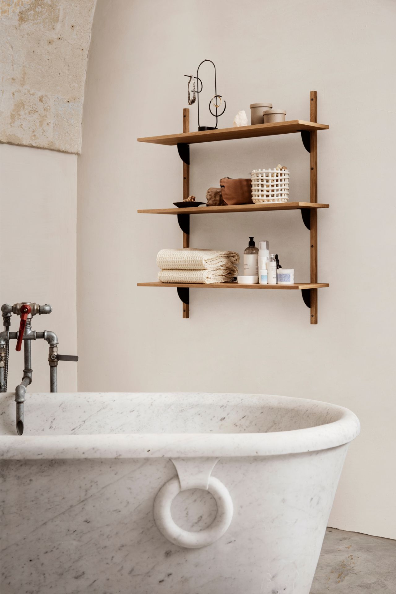 Badezimmer mit Marmorbadewanne und Holzregal mit Ferm Living Ceramic Basket Keramik Korb.