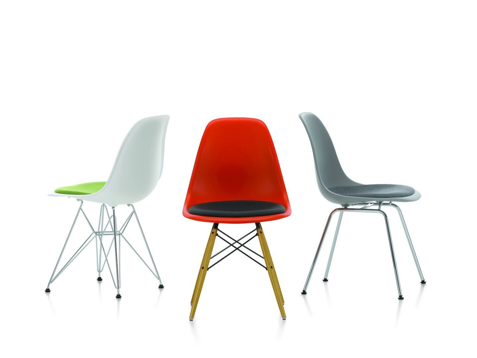 Drei Eames Plastic Side Chairs DSR von Vitra in Weiß, Rot und Grau mit Sitzpolster.