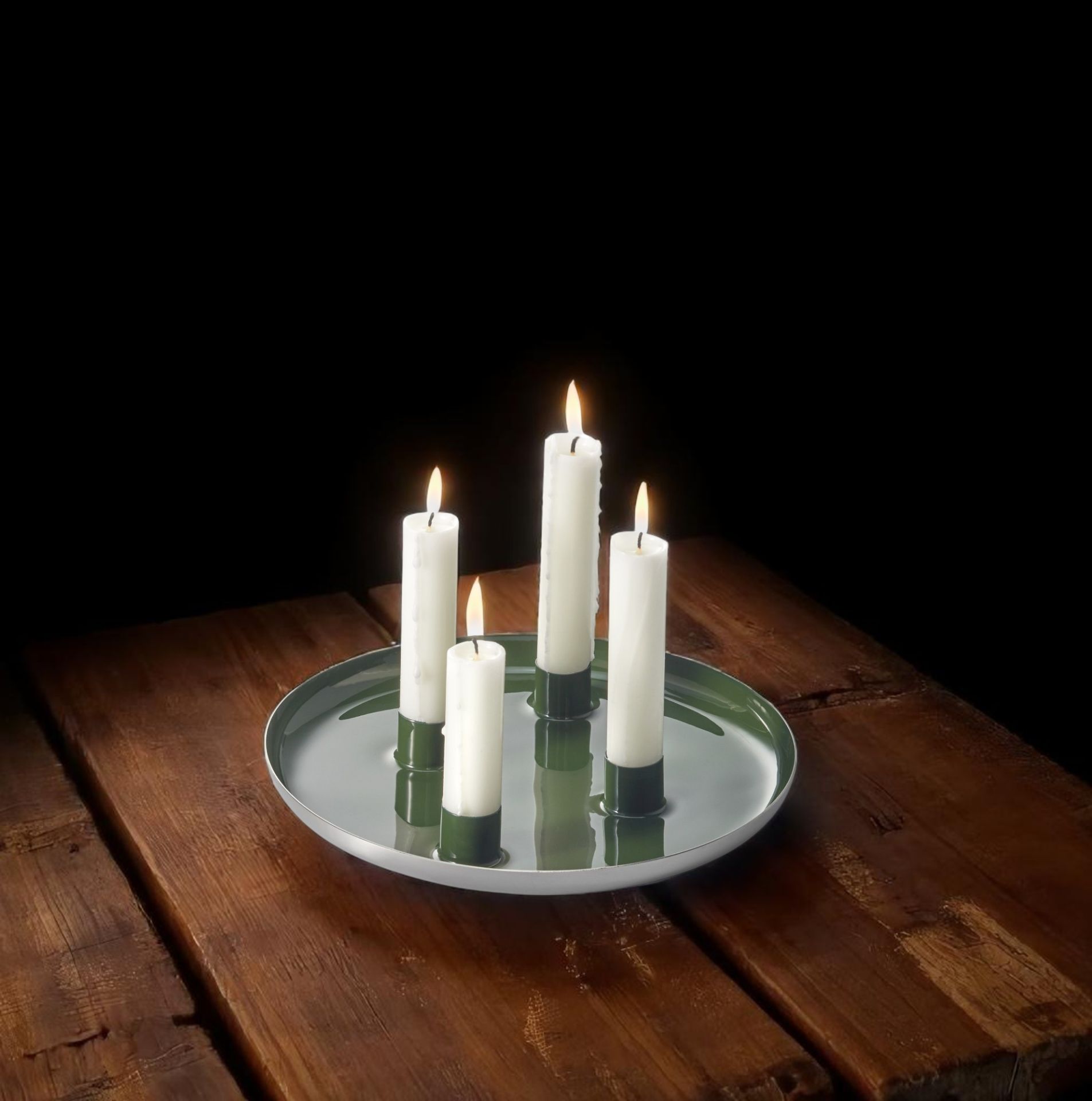 Brennende, weiße Kerzen auf dem Biel Adventsteller von Philippi aus Stahl auf einem Holztisch.