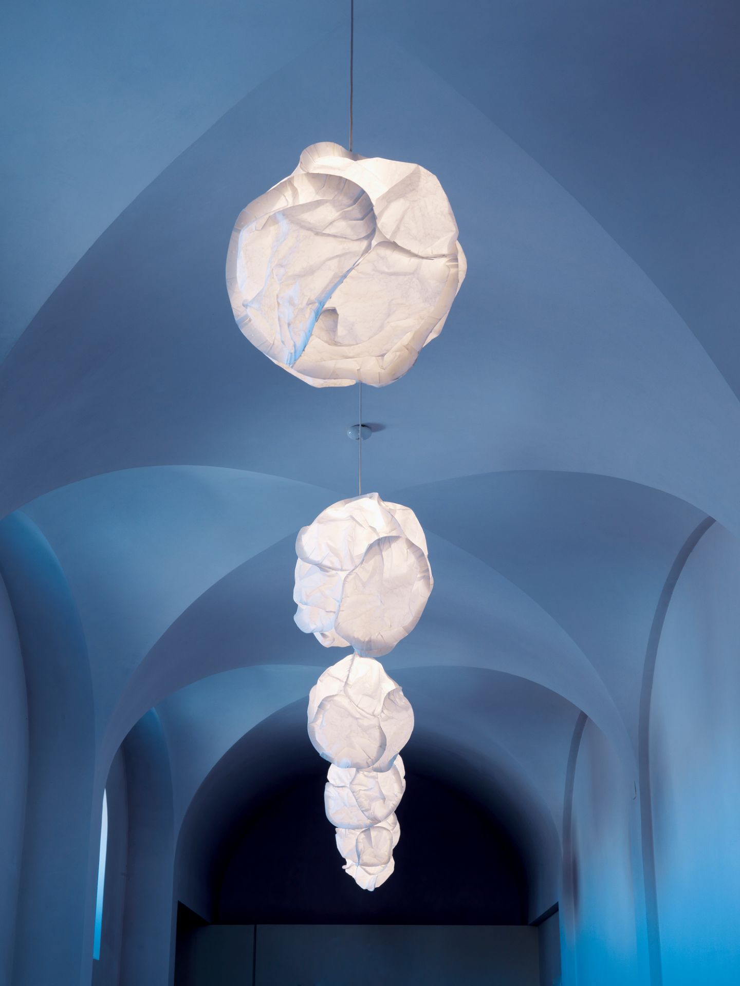 E27 Cloud Pendelleuchte Belux: Mehrere weiße Wolken-Lampen hängen in einem blauen Gewölbe. Design Hängelampe.