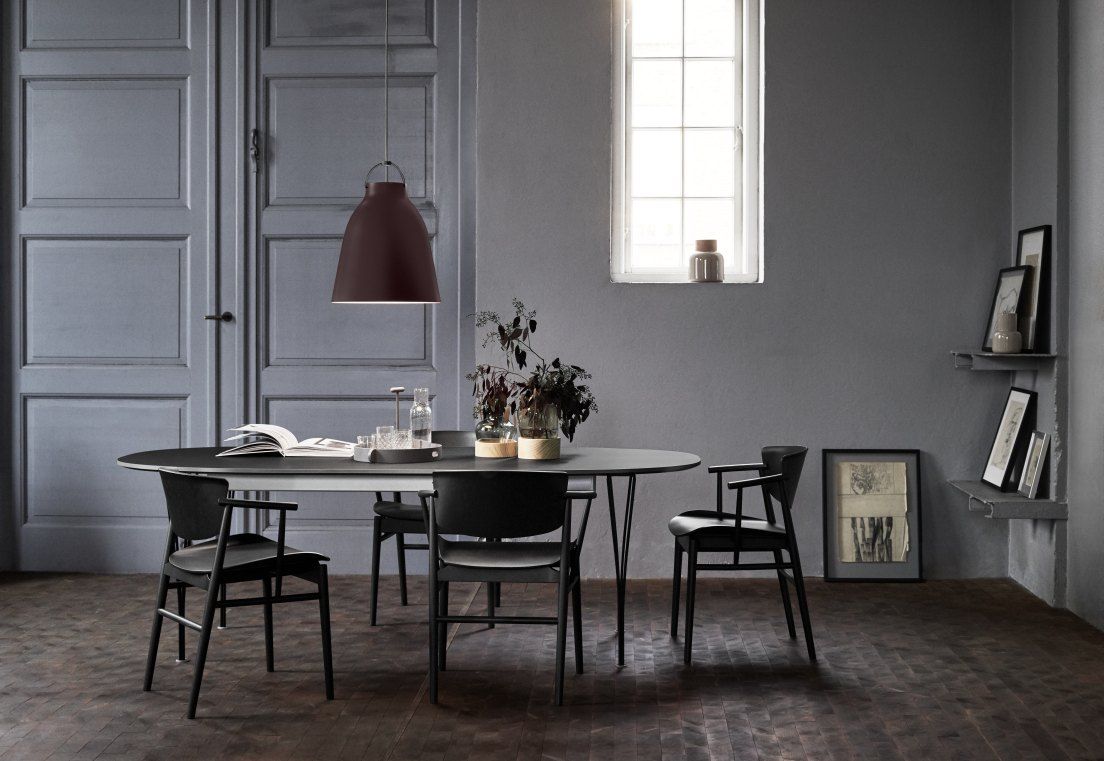 Caravaggio Pendelleuchte von Fritz Hansen über Esstisch in modernem Esszimmer mit Stühlen und Dekoration.