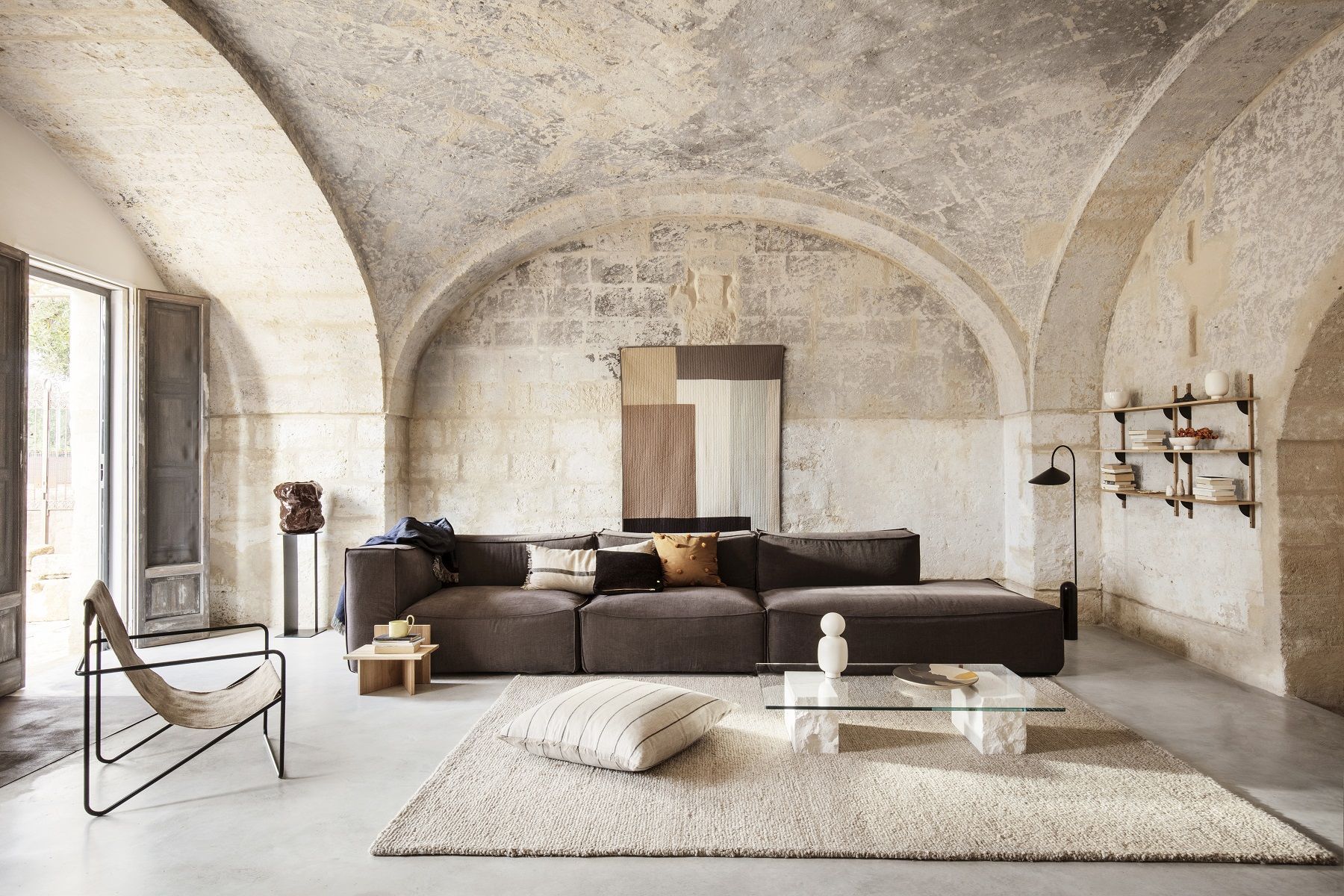 Desert Chair Loungesessel von Ferm Living in stilvollem Wohnzimmer mit Sofa, Teppich und Dekoration.