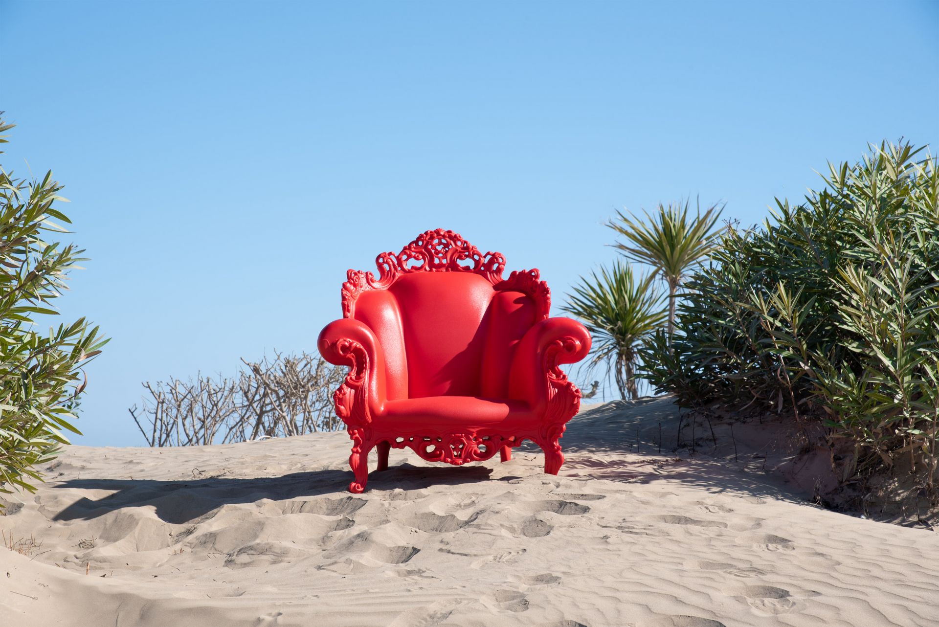 Roter Proust Sessel Outdoor von Magis auf Sanddüne vor blauem Himmel. Design Gartenmöbel.