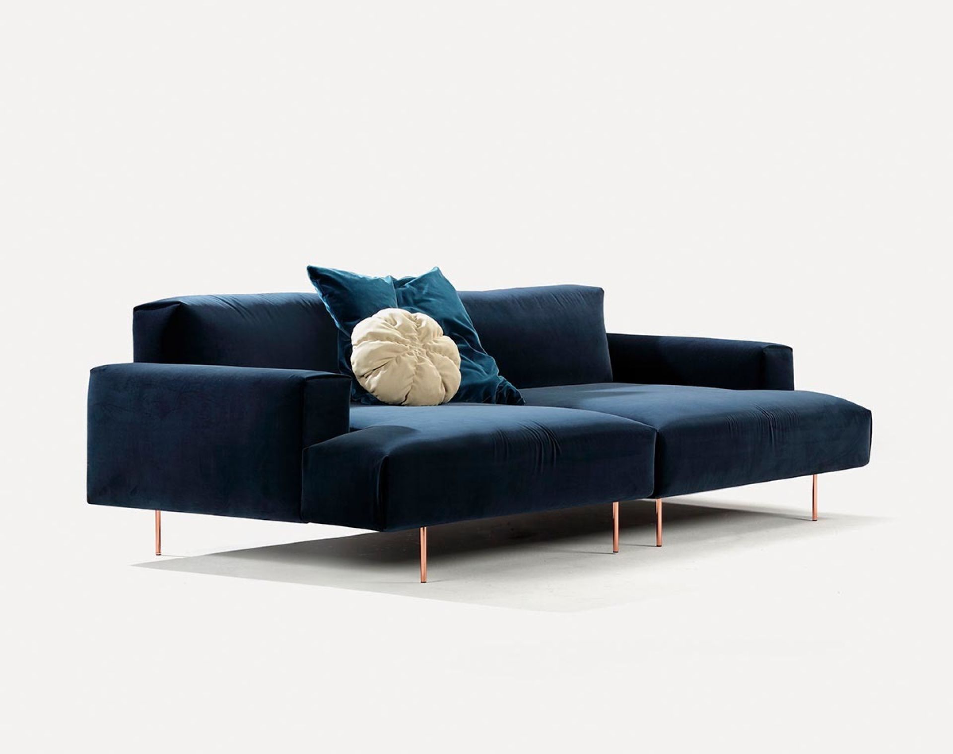 Blaues Tip Toe Sofa von Sancal mit Samtbezug und Zierkissen auf schlanken, kupferfarbenen Füßen.