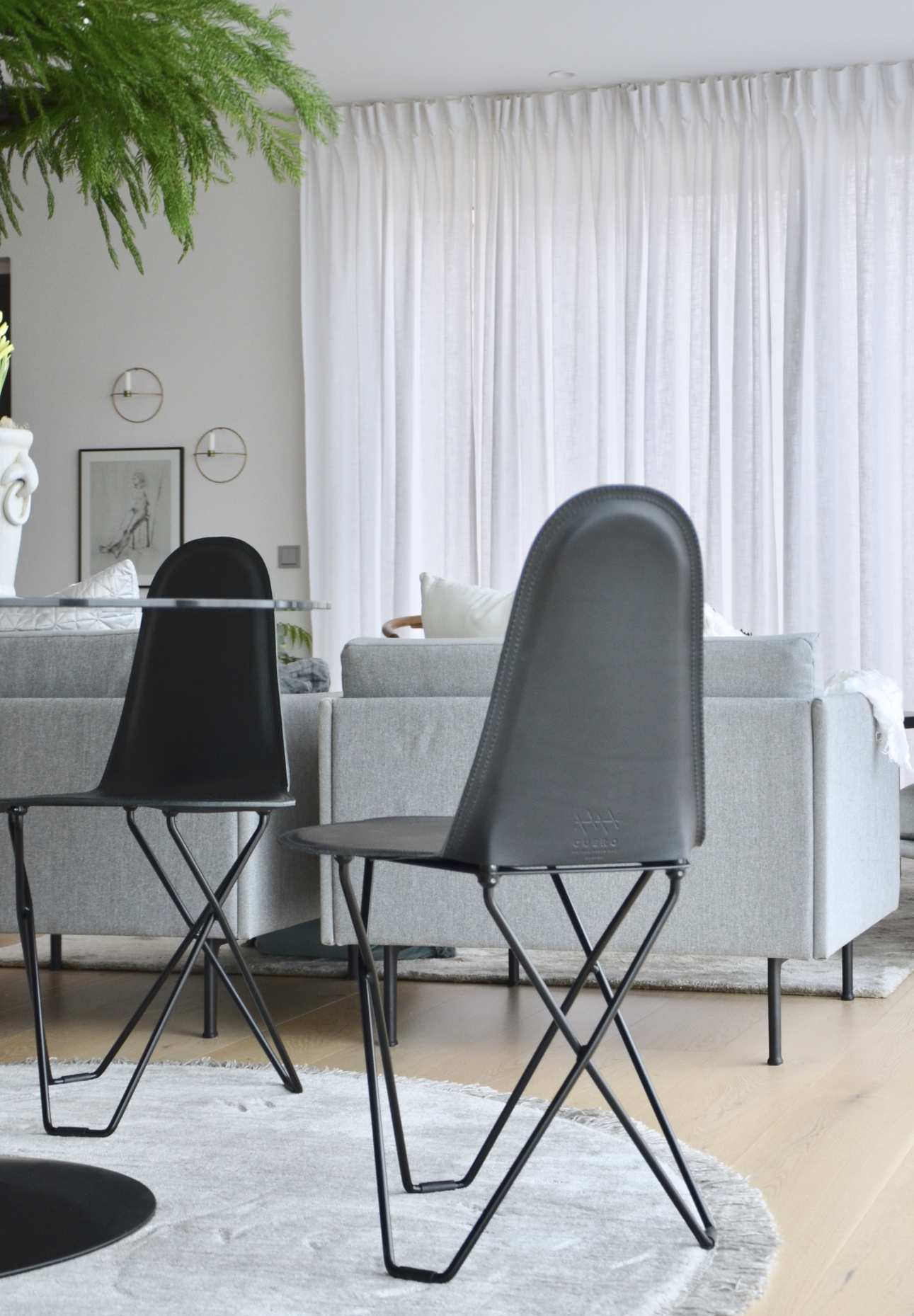Zwei Cactus Stühle mit schwarzem Lederbezug und filigranem Metallgestell im modernen Wohnzimmer.