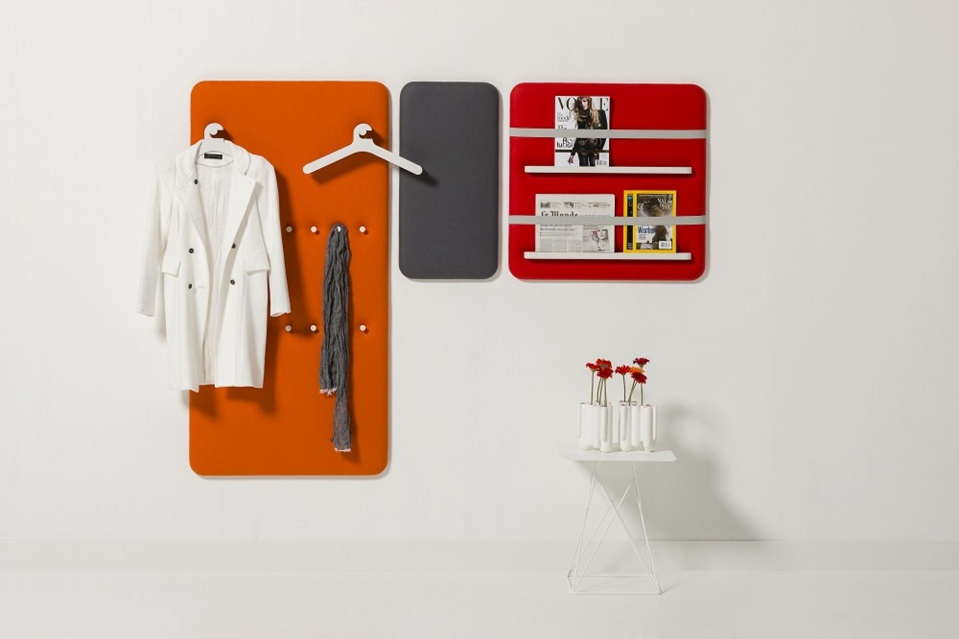 Cascando Pillow Wall Paneele: Orangefarbene Garderobe, graue Pinnwand und rotes Magazinboard an weißer Wand.