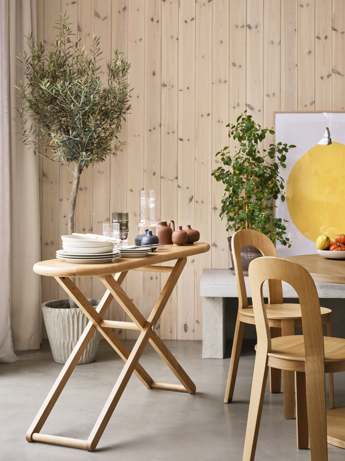 Cinderella Table von Design House Stockholm, ein klappbarer Beistelltisch aus hellem Holz mit Geschirr.