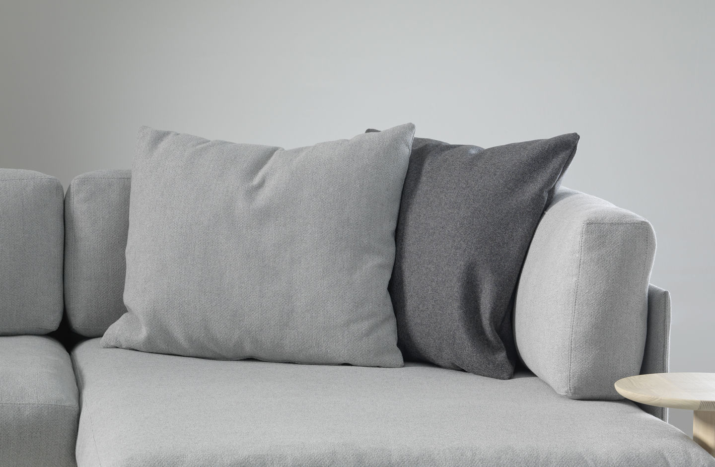 Vitra Kissen: Hellgraues und dunkelgraues Sofakissen aus Stoff auf einem grauen Sofa.