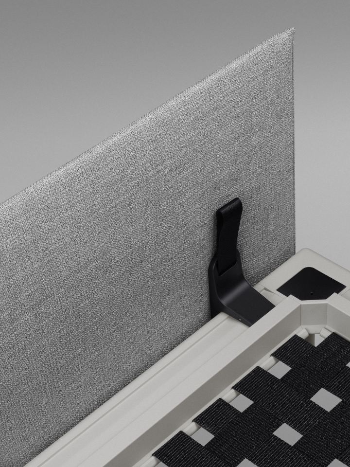 Detailaufnahme des Vitra Anagram Panel 90 cm in Grau, befestigt an einem weißen Möbelstück mit schwarzem Gurtband.
