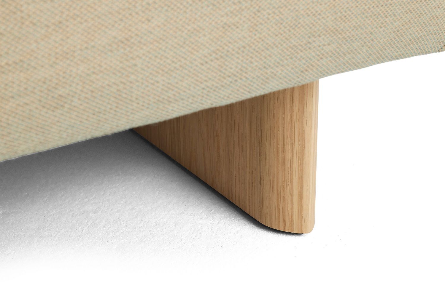 Detailaufnahme vom Holzfuß des Quilton Sofas von Hay mit beigem Stoffbezug.