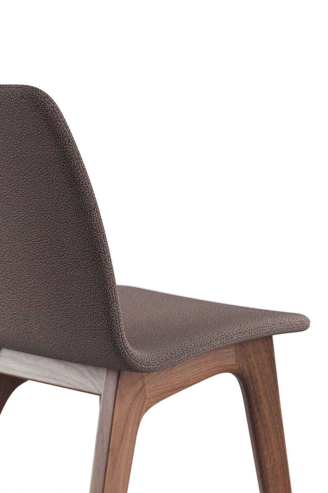 Detailaufnahme: Morph Holzstuhl mit braunem Stoffbezug und elegantem Holzgestell. Designstuhl für Esszimmer.
