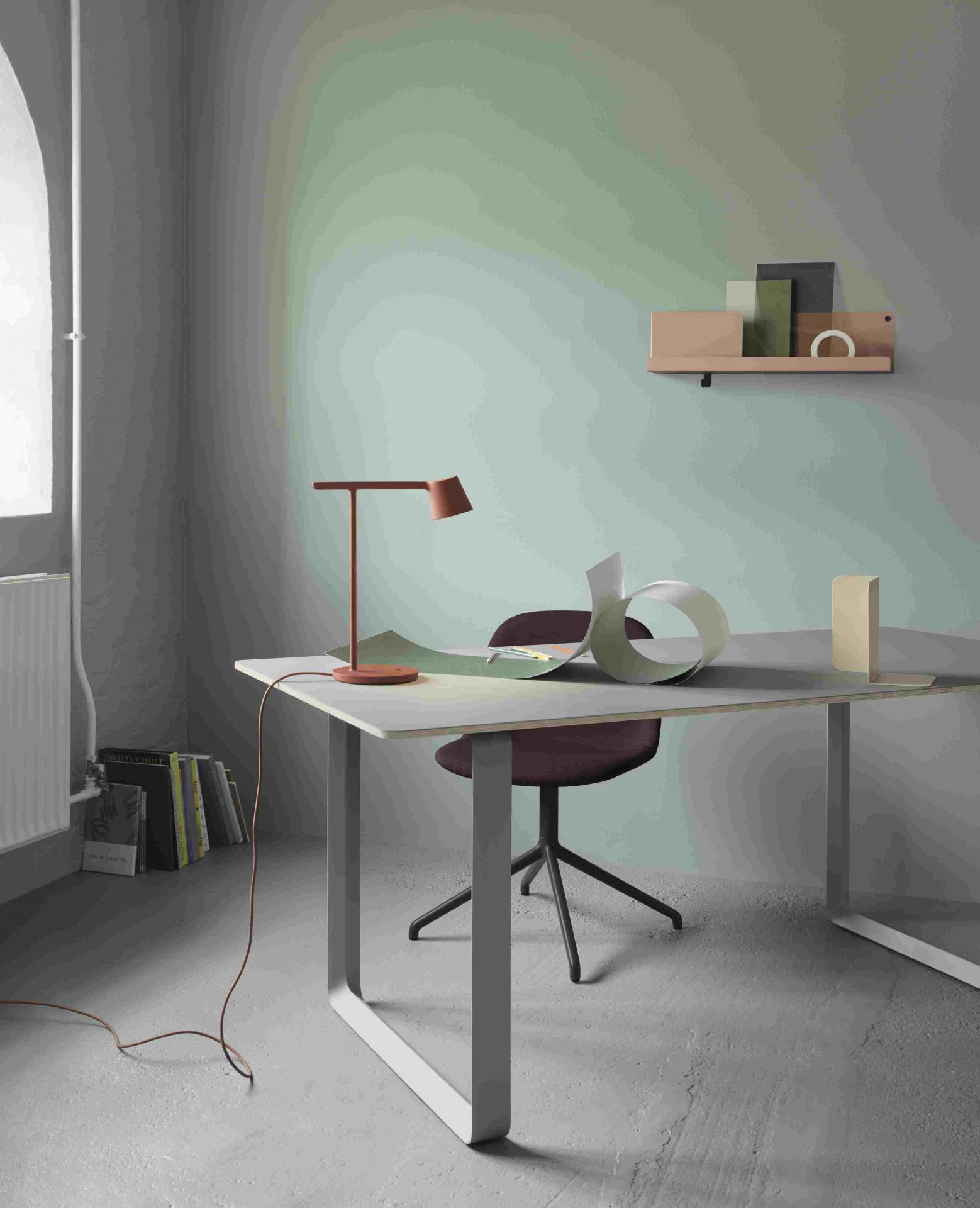 Nahaufnahme der Muuto Tip Table Lamp Tischleuchte in Kupfer auf einem Schreibtisch im minimalistischen Büro.
