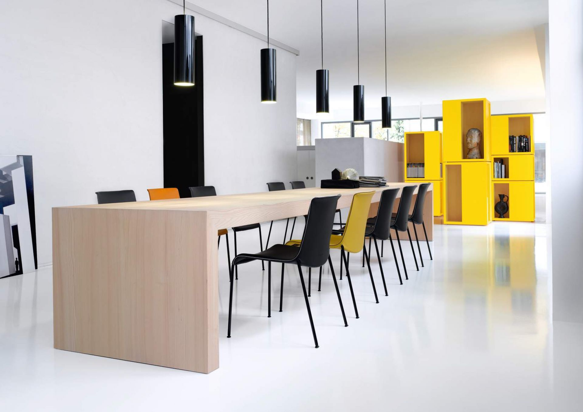 Liz Stuhl von Walter Koll an langem Holztisch in modernem, minimalistischem Büro mit gelben Regalen.