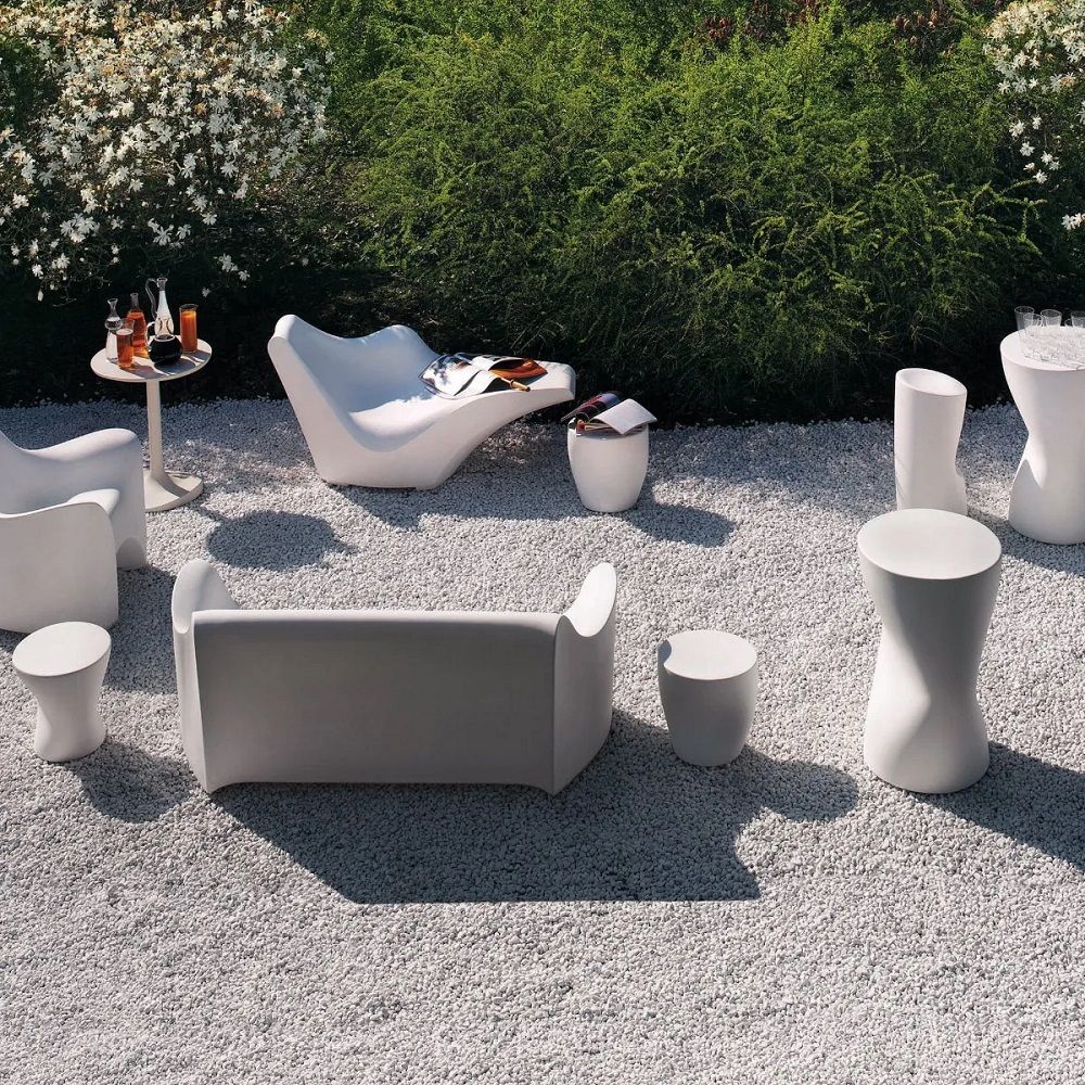 Driade TOKYO-POP Outdoor Möbel-Set in Weiß, bestehend aus Tisch, Hocker, Liege und Sofa auf Kiesfläche.