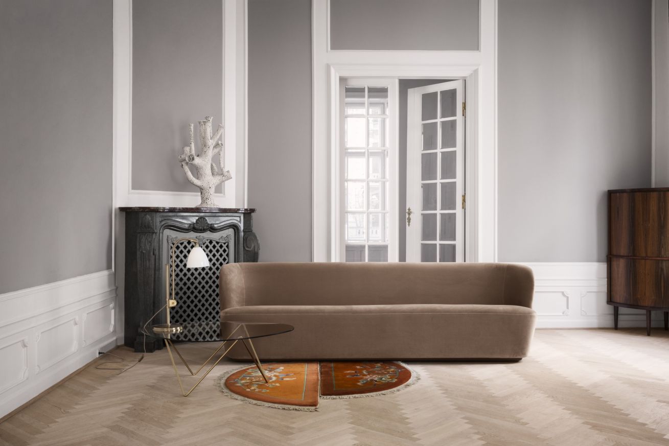 Wohnzimmer mit braunem Sofa und Pedrera Couchtisch von Gubi mit Messinggestell.