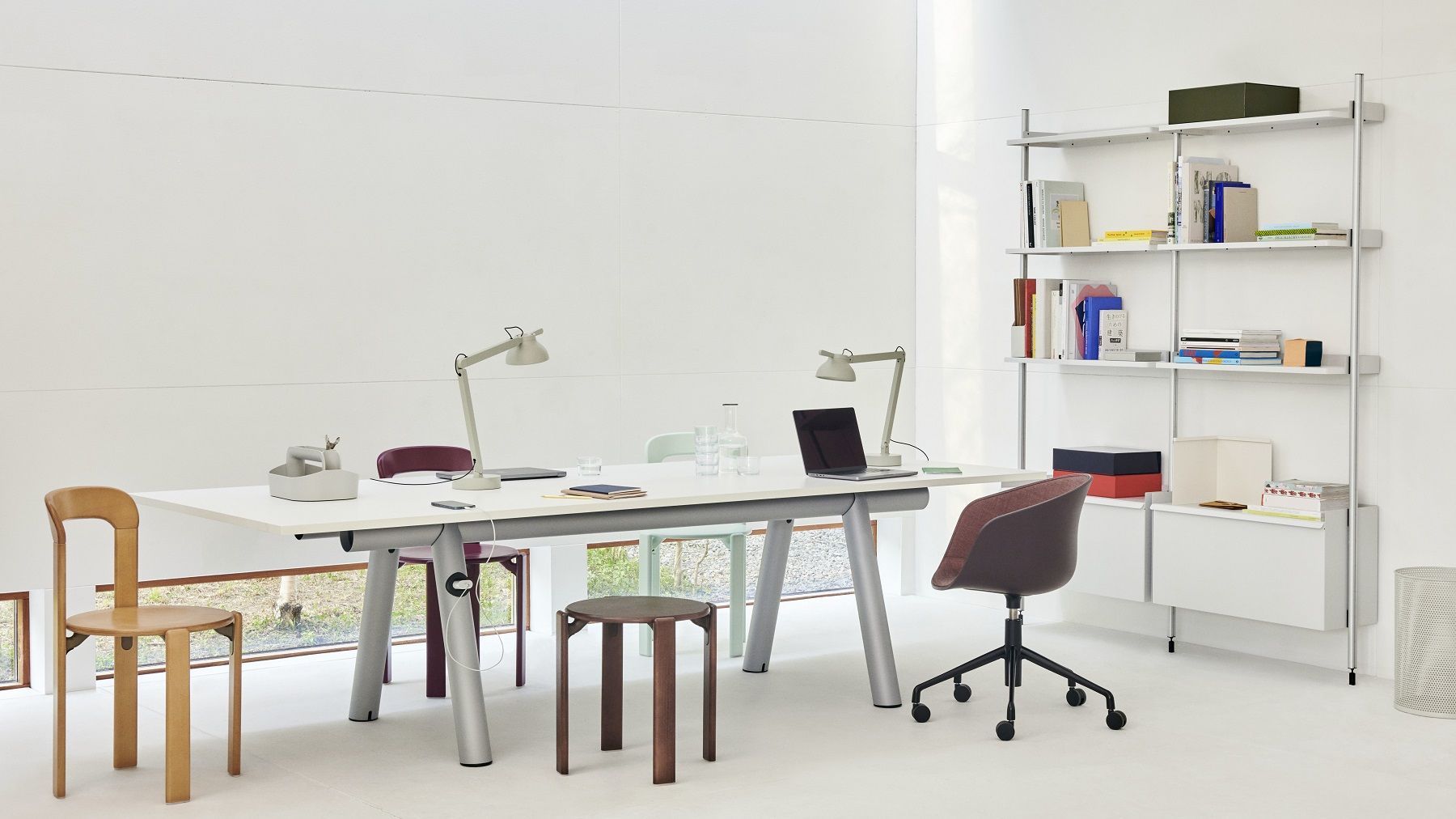 Büro mit Rey Stool Hocker von Hay, Schreibtisch, Regalen und Büromaterial in minimalistischem Design.