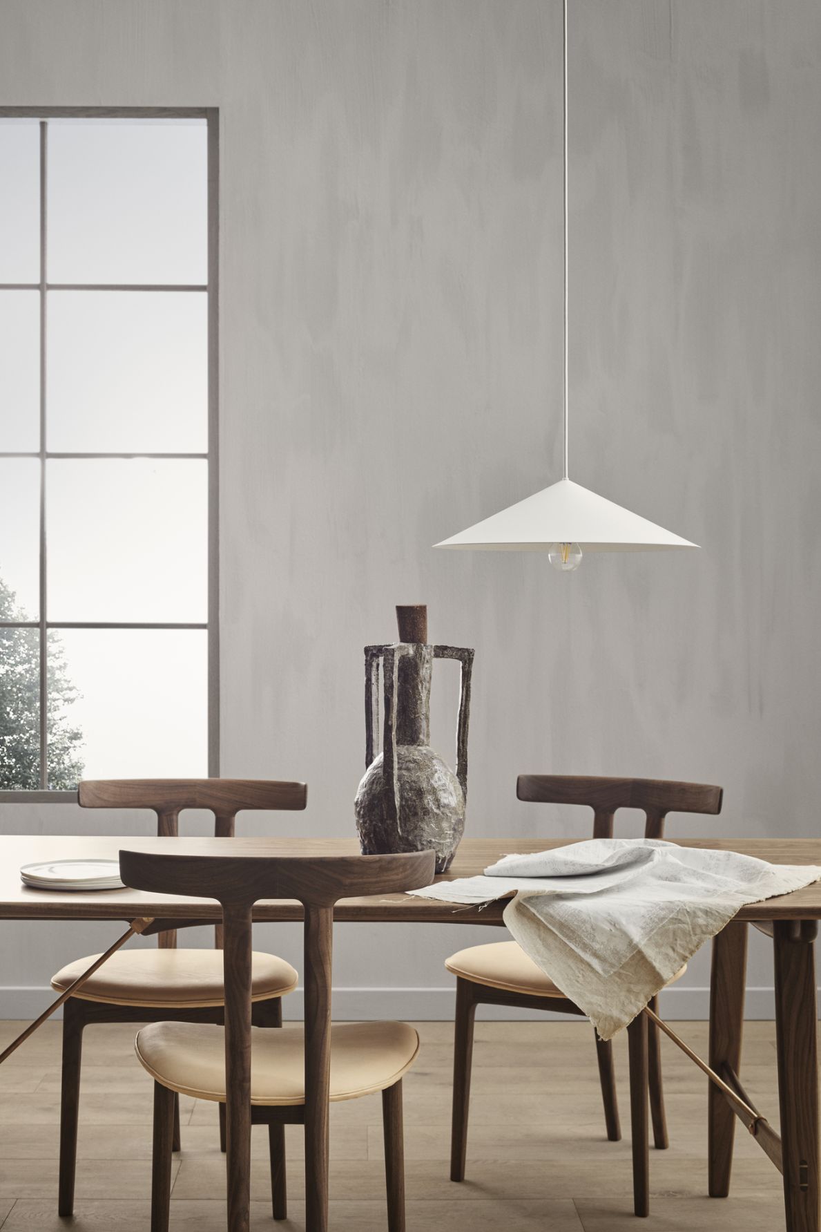 BT1001 Pendelleuchte von Carl Hansen & Søn über Esstisch mit Stühlen und Dekoration.