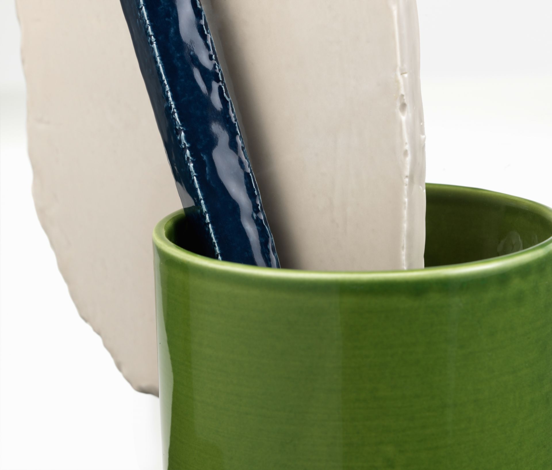 Vitra Découpage Vase: Grüne Keramikvase mit abstrakten, weißen und blauen Keramikformen als moderne Dekoration.