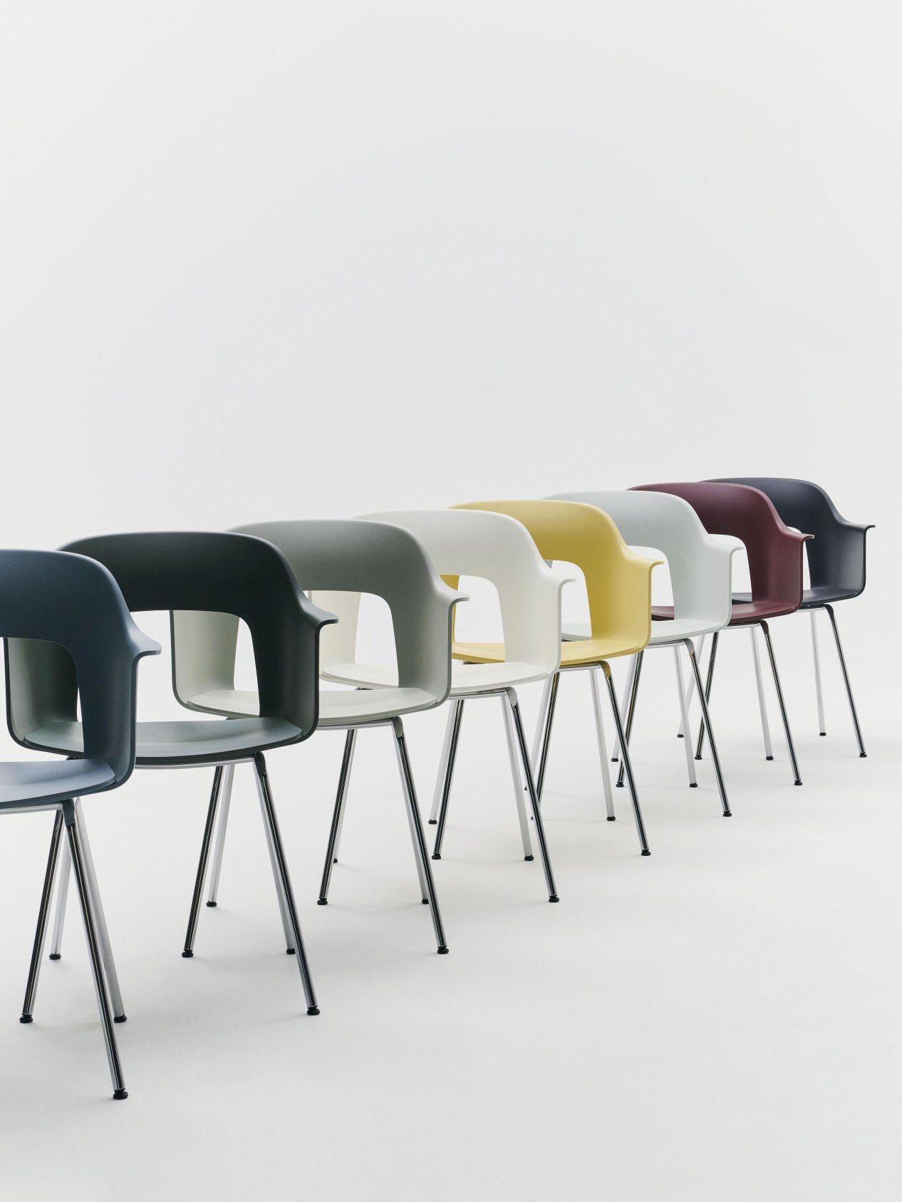 Reihe von Hay Layout Armchair 211 Stühlen in verschiedenen Farben mit Stahlbeinen auf weißem Hintergrund.