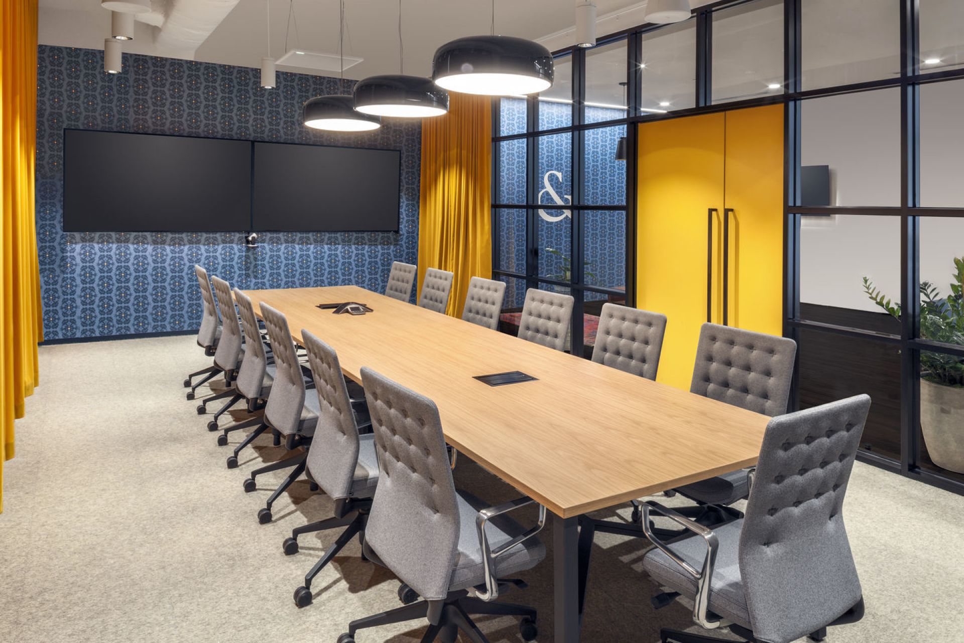 Konferenzraum mit langem Holztisch und grauen ID Trim Bürodrehstühlen von Vitra für moderne Büroeinrichtung.