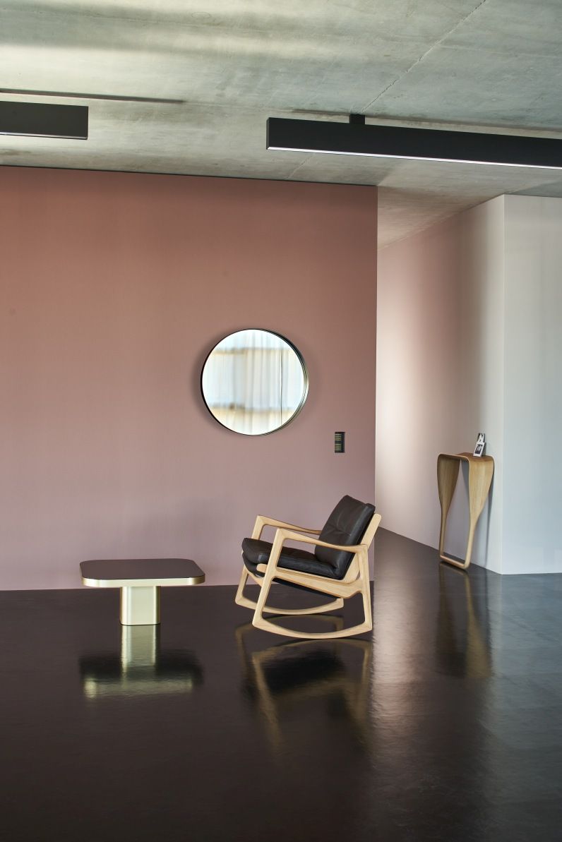 ClassiCon Bow Coffee Table No. 2 in modernem Wohnzimmer mit Sessel und Spiegel.