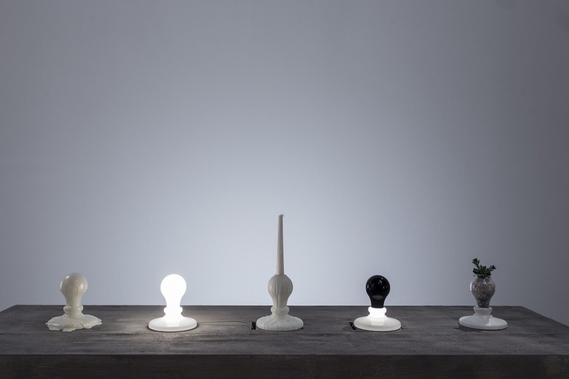Fünf Foscarini Light Bulb Tavolo LED Tischleuchten in Weiß und Schwarz auf einem Tisch.