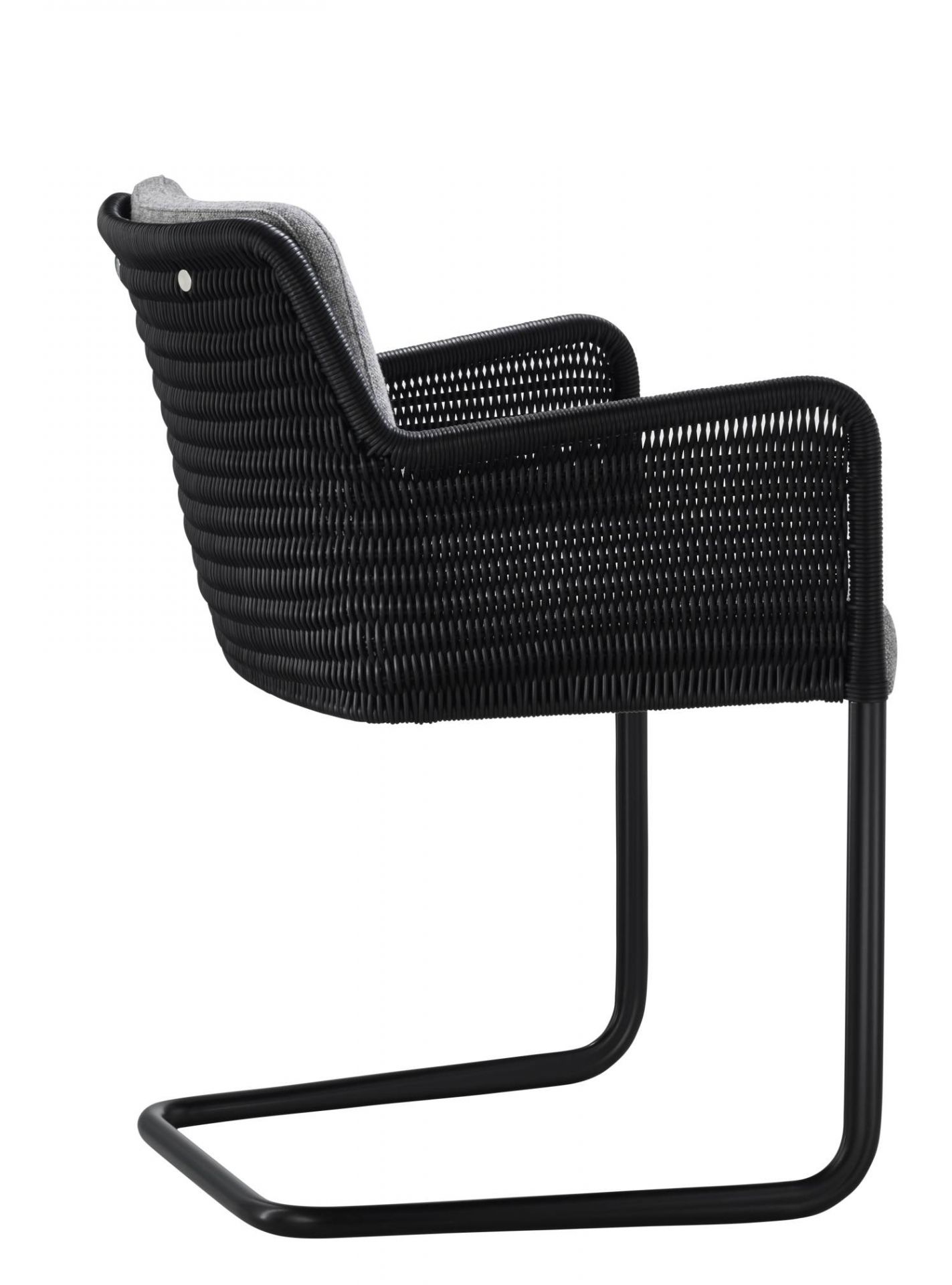Schwarzer D43 Kragstuhl Freischwinger Tecta mit Rattan Geflecht und grauem Sitzkissen, Seitenansicht. Design Stuhl für Wohnzimmer.