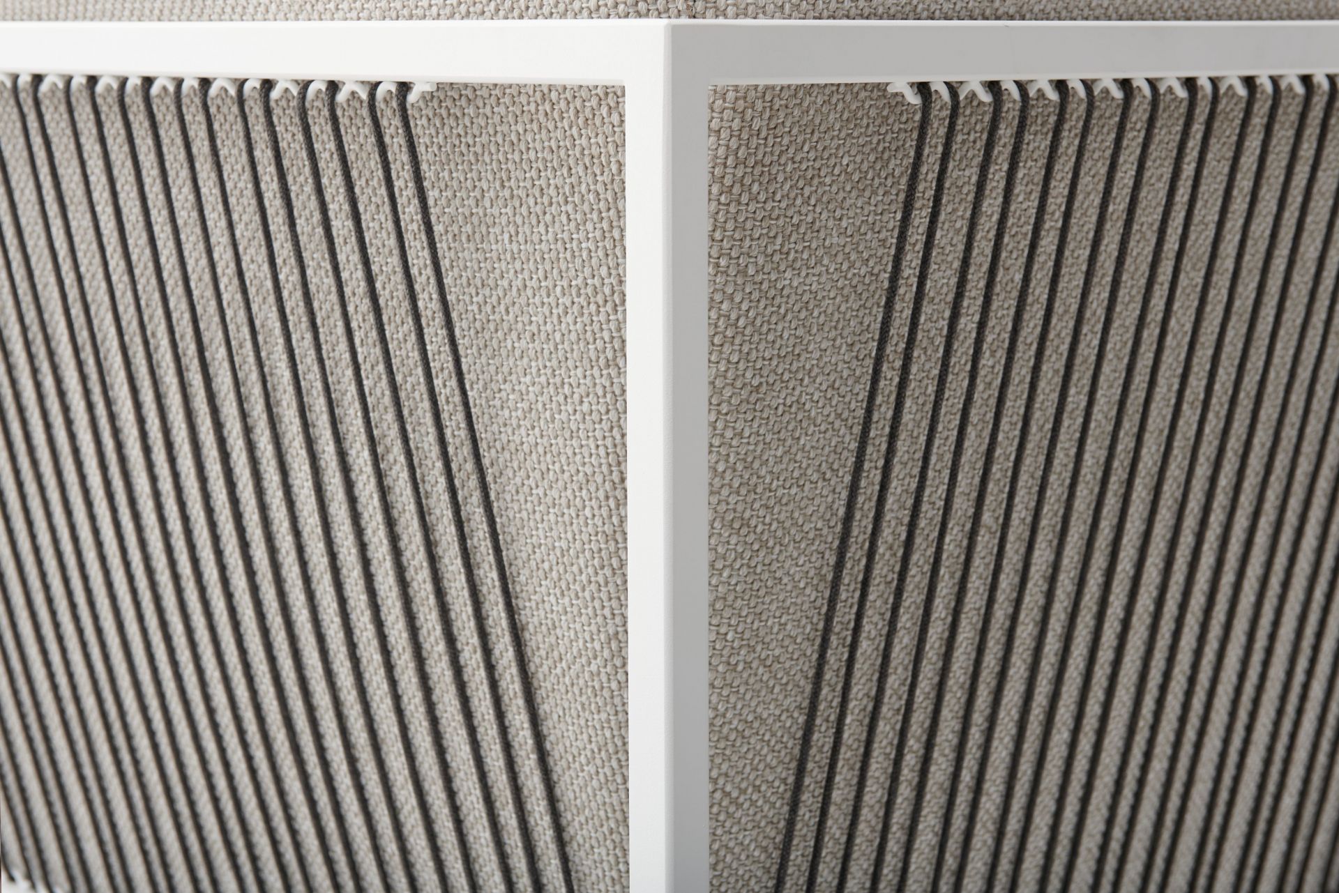 Detailaufnahme des Arpa Outdoor Sofas von MDF Italia: Weiße Rahmenstruktur mit grauem Textilbezug und vertikalen Schnüren.