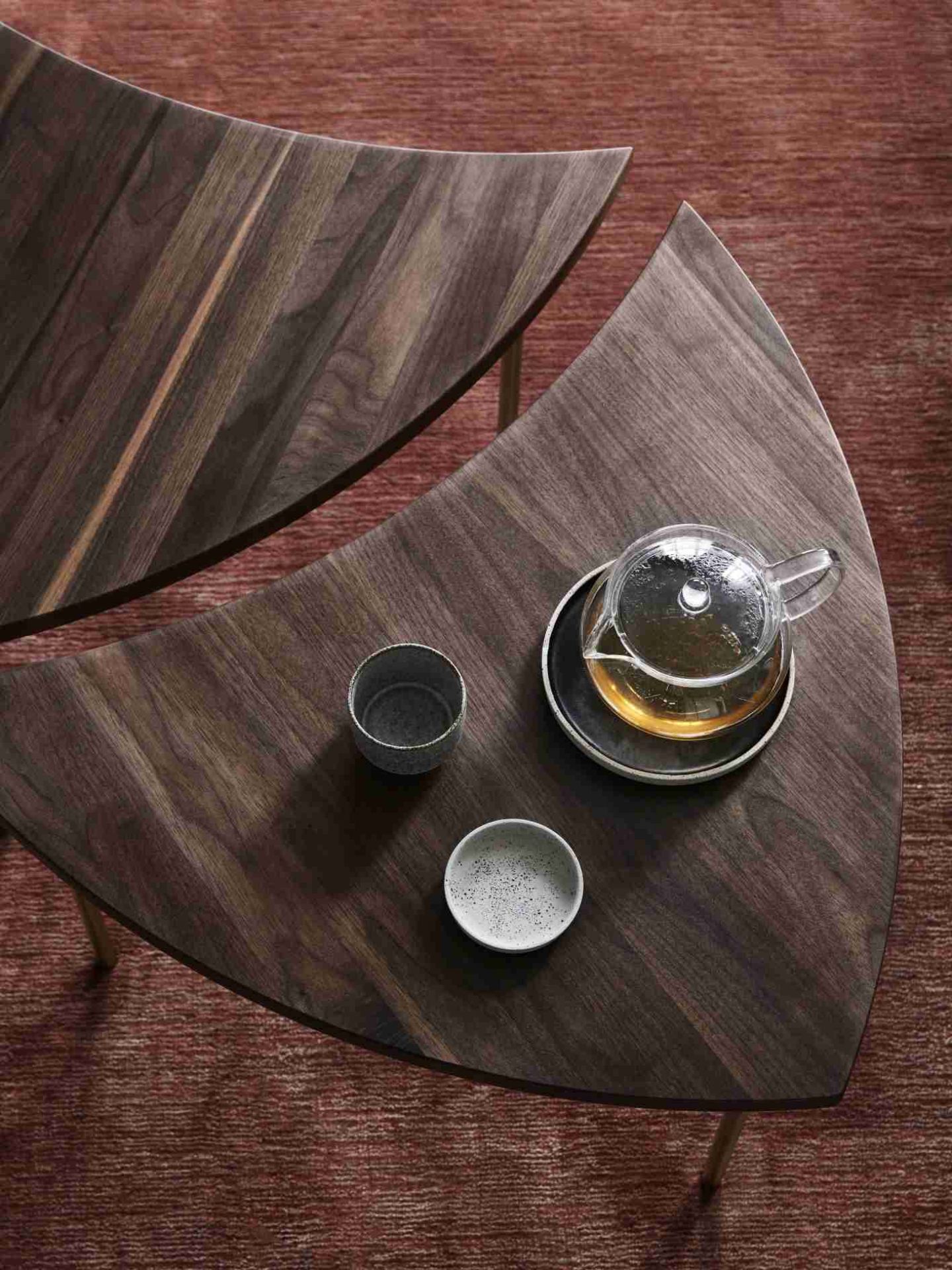 Detailaufnahme des AndTradition The Moor Rug Teppichs mit Teekanne und Tassen auf einem Holztisch.