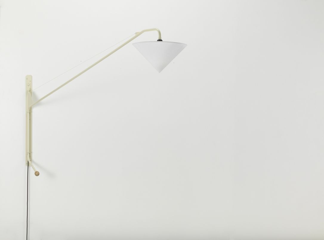 Nahaufnahme der Vitra Potence Wandleuchte mit konischem Lampenschirm in Weiß vor einer weißen Wand.