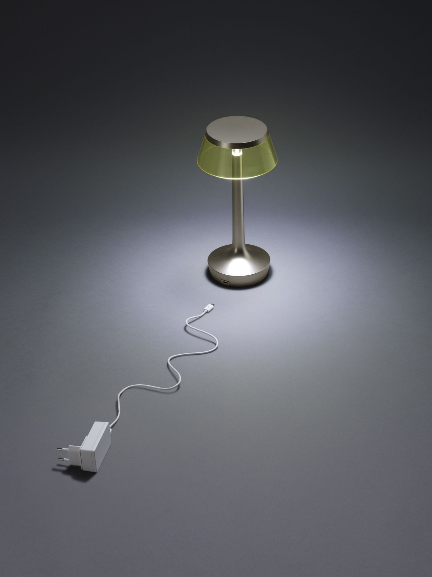 Bon Jour Unplugged Tischleuchte Flos in Chrom mit gelbem Schirm und Ladekabel.