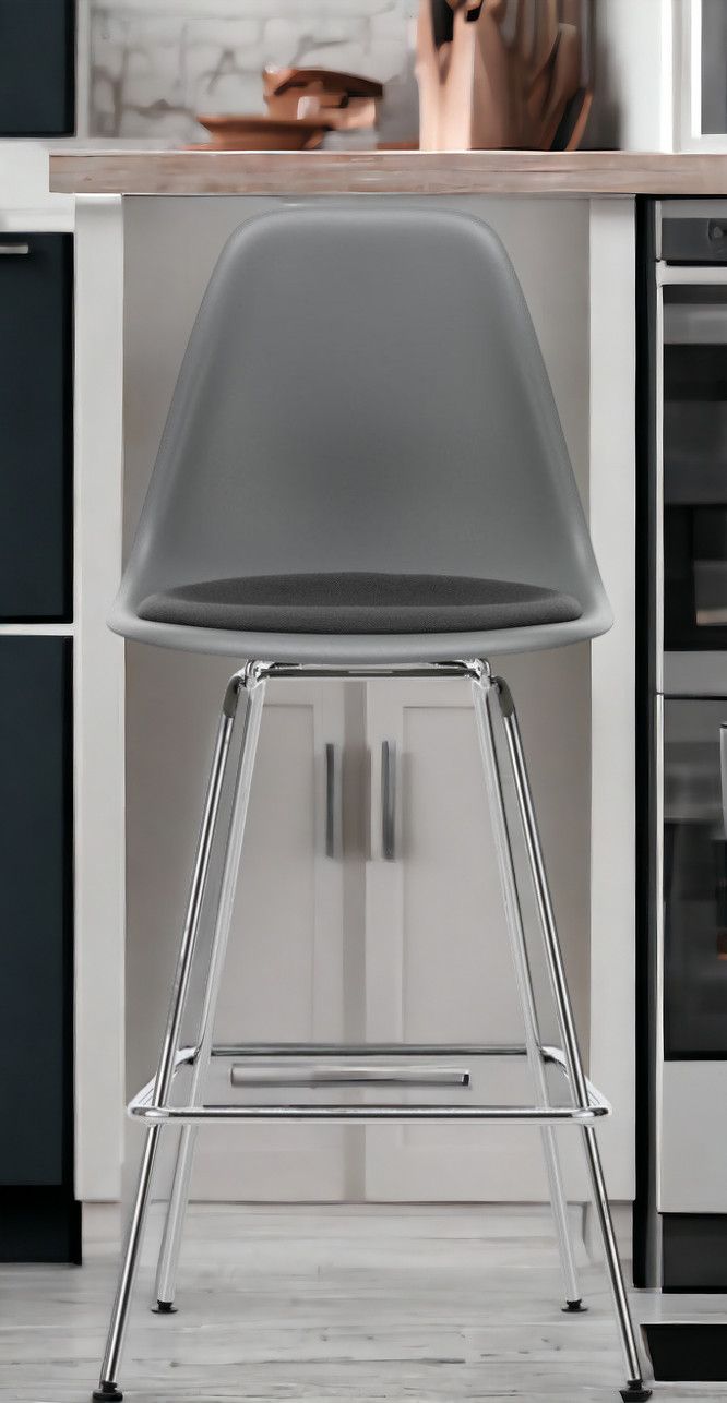 Grauer Eames Plastic Bar Stool Barhocker Medium von Vitra mit Sitzpolster und verchromtem Gestell.