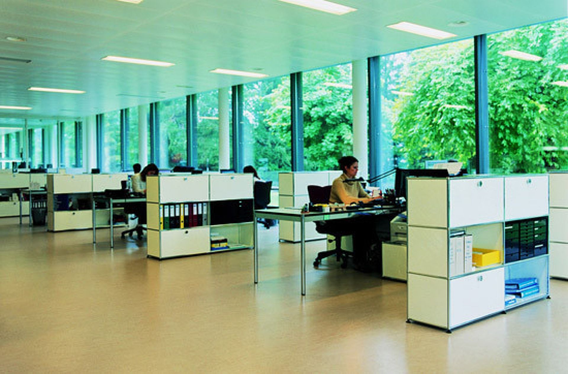 Helles Büro mit USM Haller Tischen und Sideboards in Perlgrau, modulare Büromöbel für moderne Arbeitsplätze.