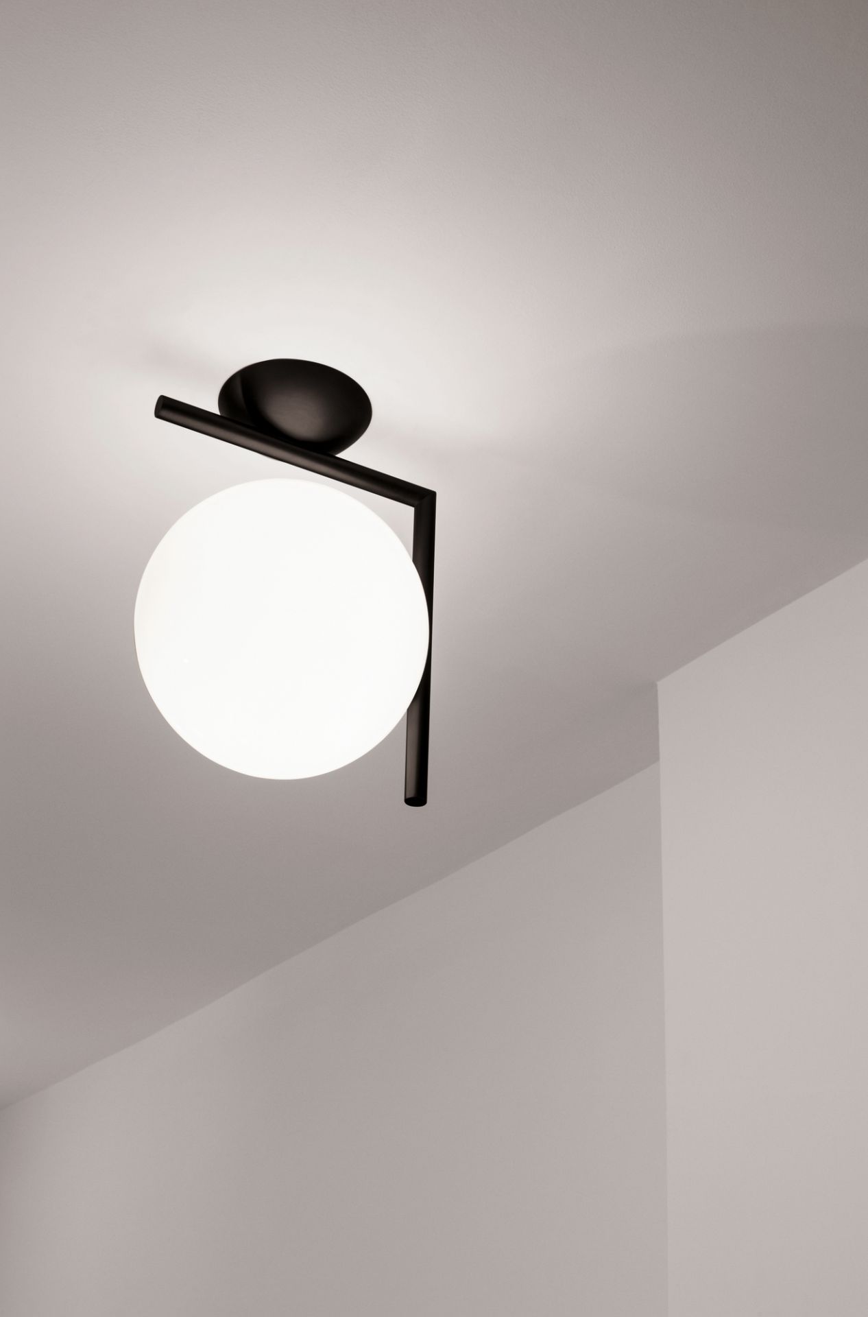 IC Lights Wandleuchte von Flos: Moderne Deckenleuchte mit schwarzem Gestell und weißem Opalglas.