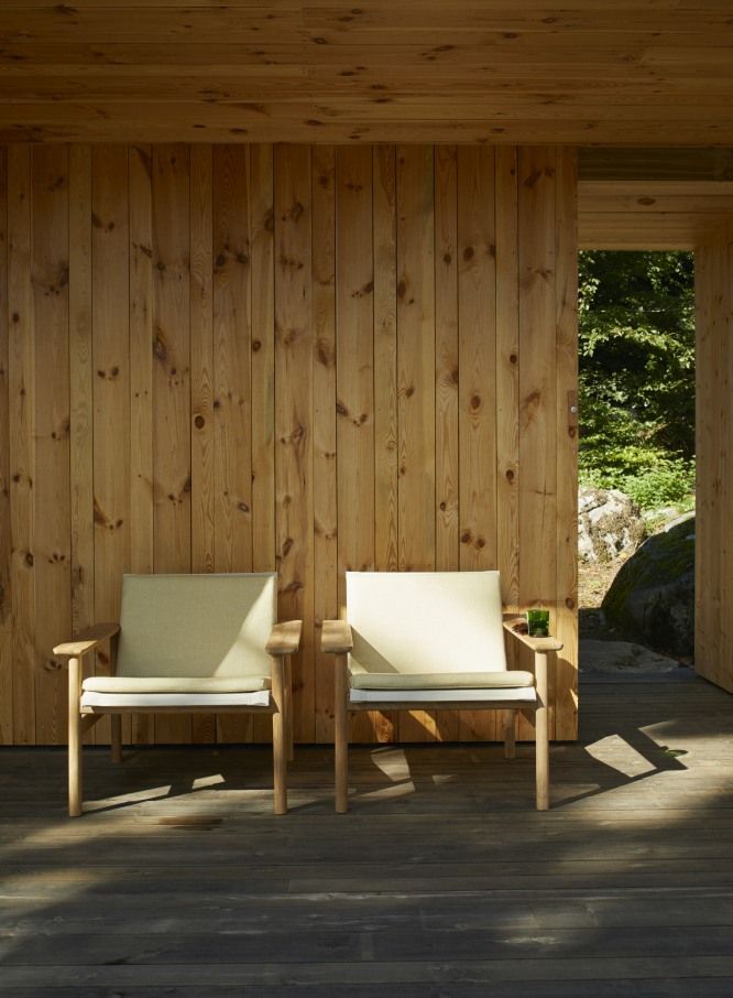 Zwei Pelagus Lounge Sessel von Skagerak by Fritz Hansen auf einer Holzterrasse im Freien.
