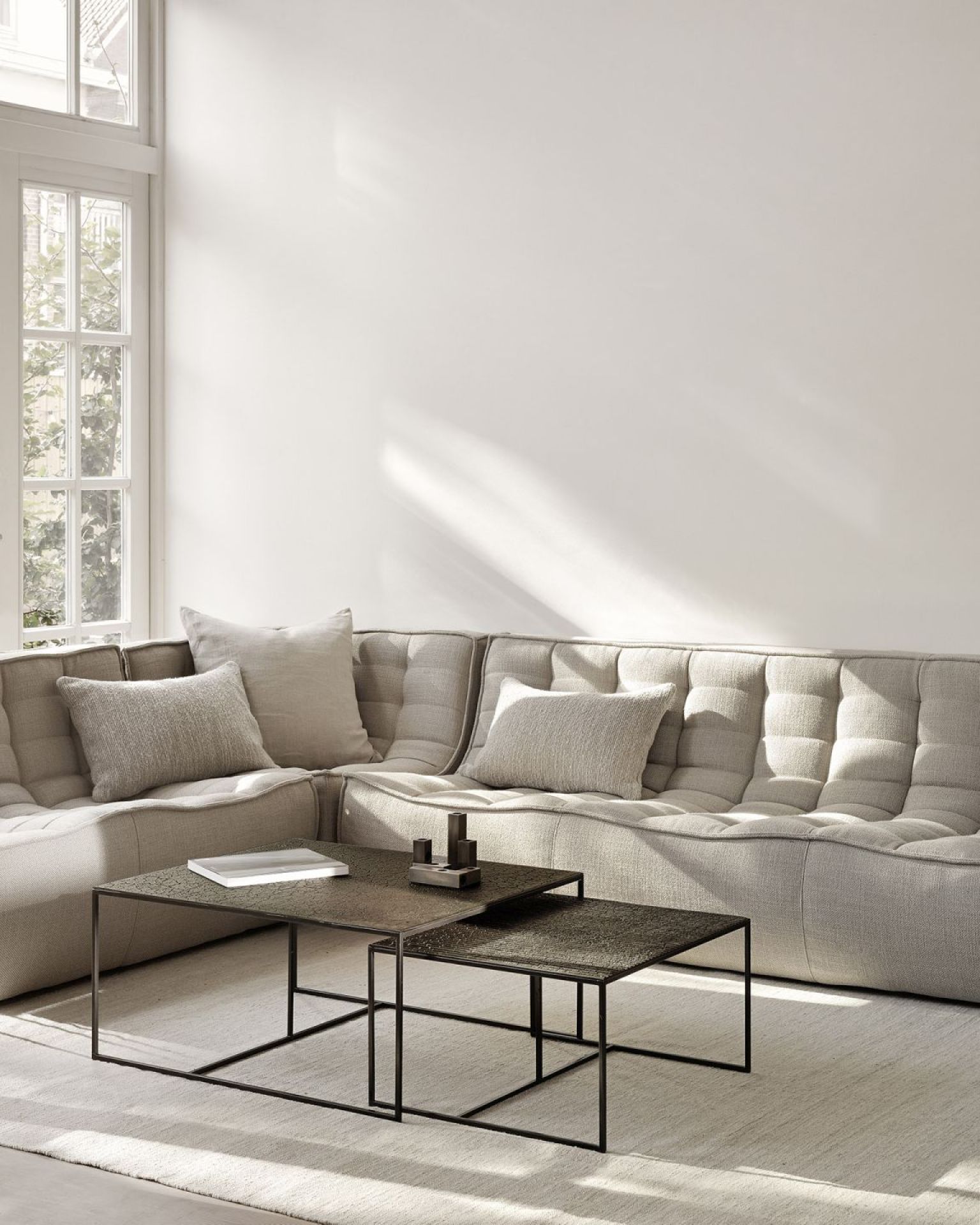 Pentagon Couchtisch 2er Set Whisky Ethnicraft vor einem hellen Sofa im Wohnzimmer.
