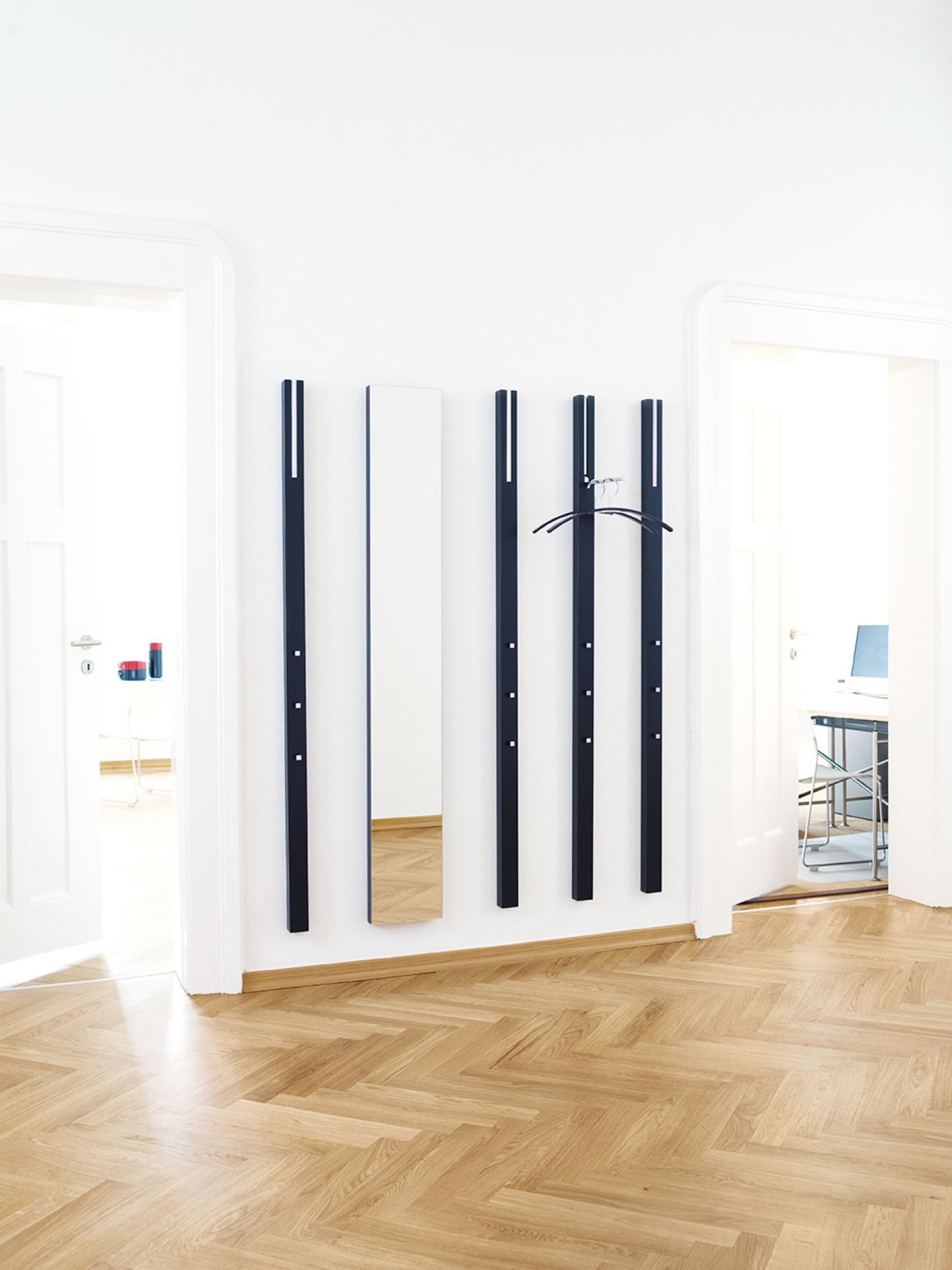 Line Garderobenelement von Schönbuch in indisch Gelb mit Spiegel und Kleiderbügel an der Wand.