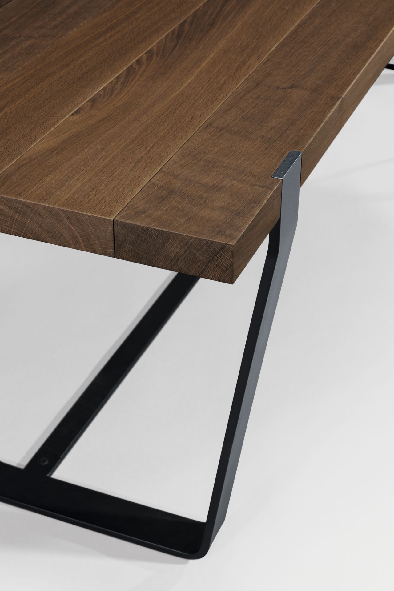 Detailaufnahme vom Janua BB 11 Clamp Tisch mit geräucherter Eichenplatte und schwarzem Metallgestell.