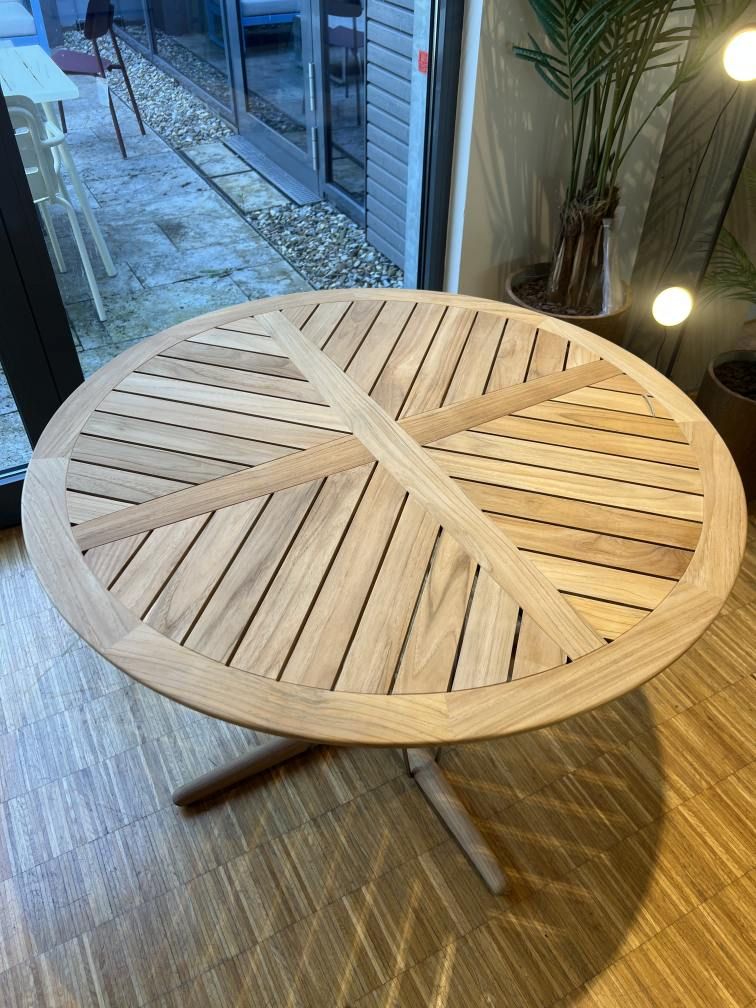 Embrace Tischkombination Outdoor von Carl Hansen & Søn: Runder Gartentisch aus Teakholz mit filigranem Untergestell.