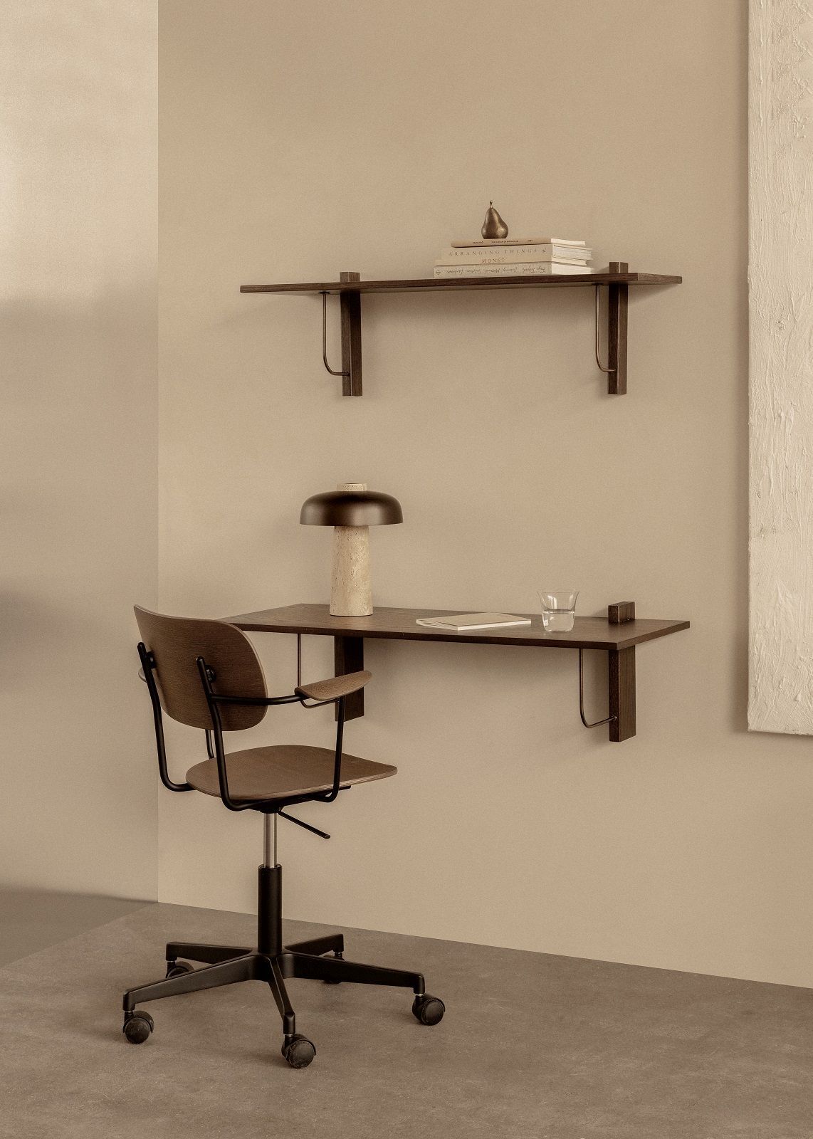 Corbel Wall Desk von Audo Copenhagen mit Bürostuhl, Lampe und Dekoration an beiger Wand.