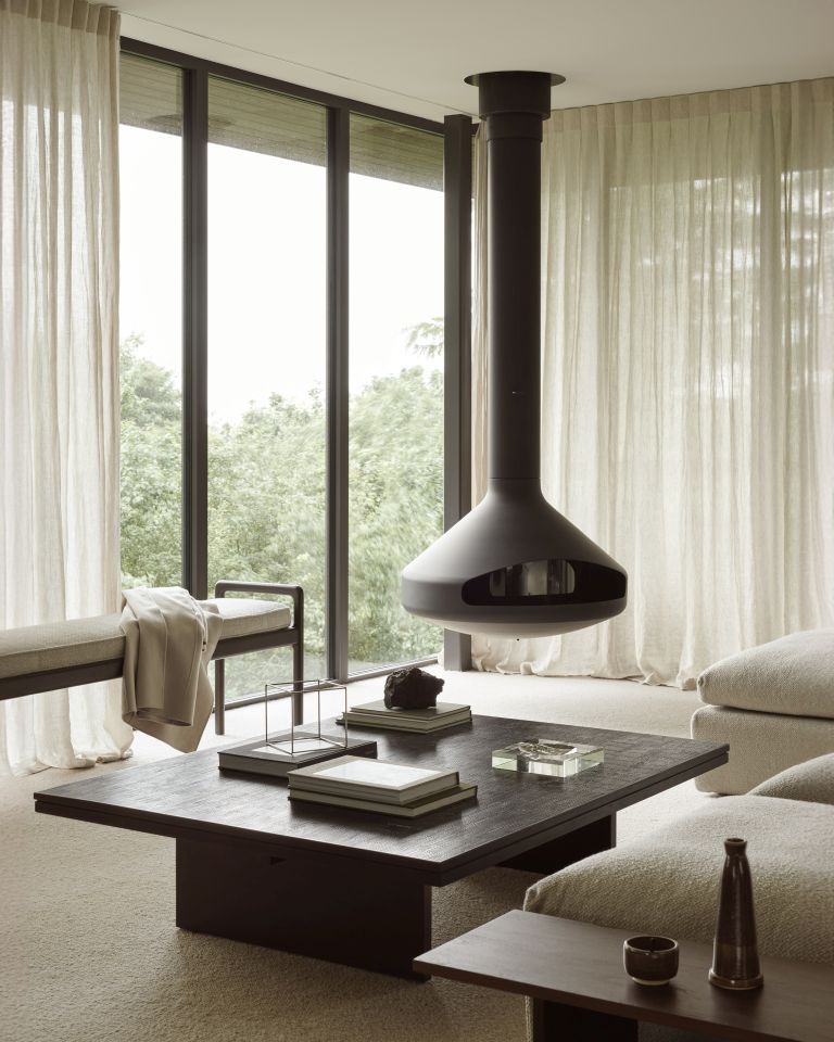 Jack Bench Bank mit Sitzpolster Ivory Ethnicraft im modernen Wohnzimmer mit Kamin und großem Fenster.