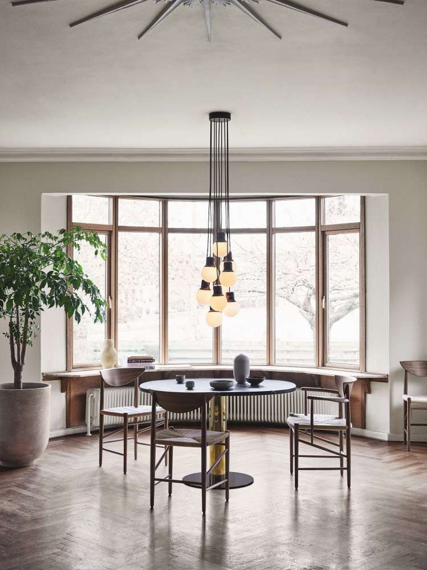AndTradition Drawn HM3 Stuhl ohne Armlehnen aus Holz und Rattan in Esszimmer-Szene.
