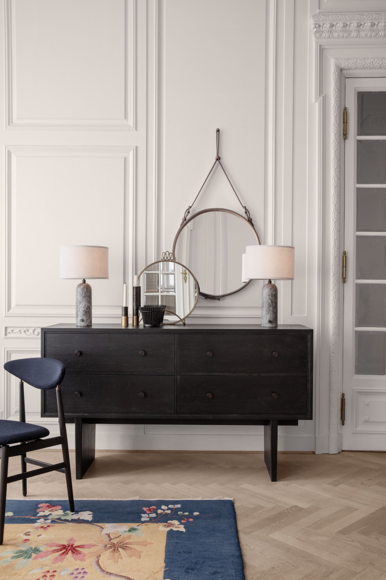 Zwei Gravity Tischleuchten von Gubi auf einer schwarzen Kommode in einem eleganten Interieur.