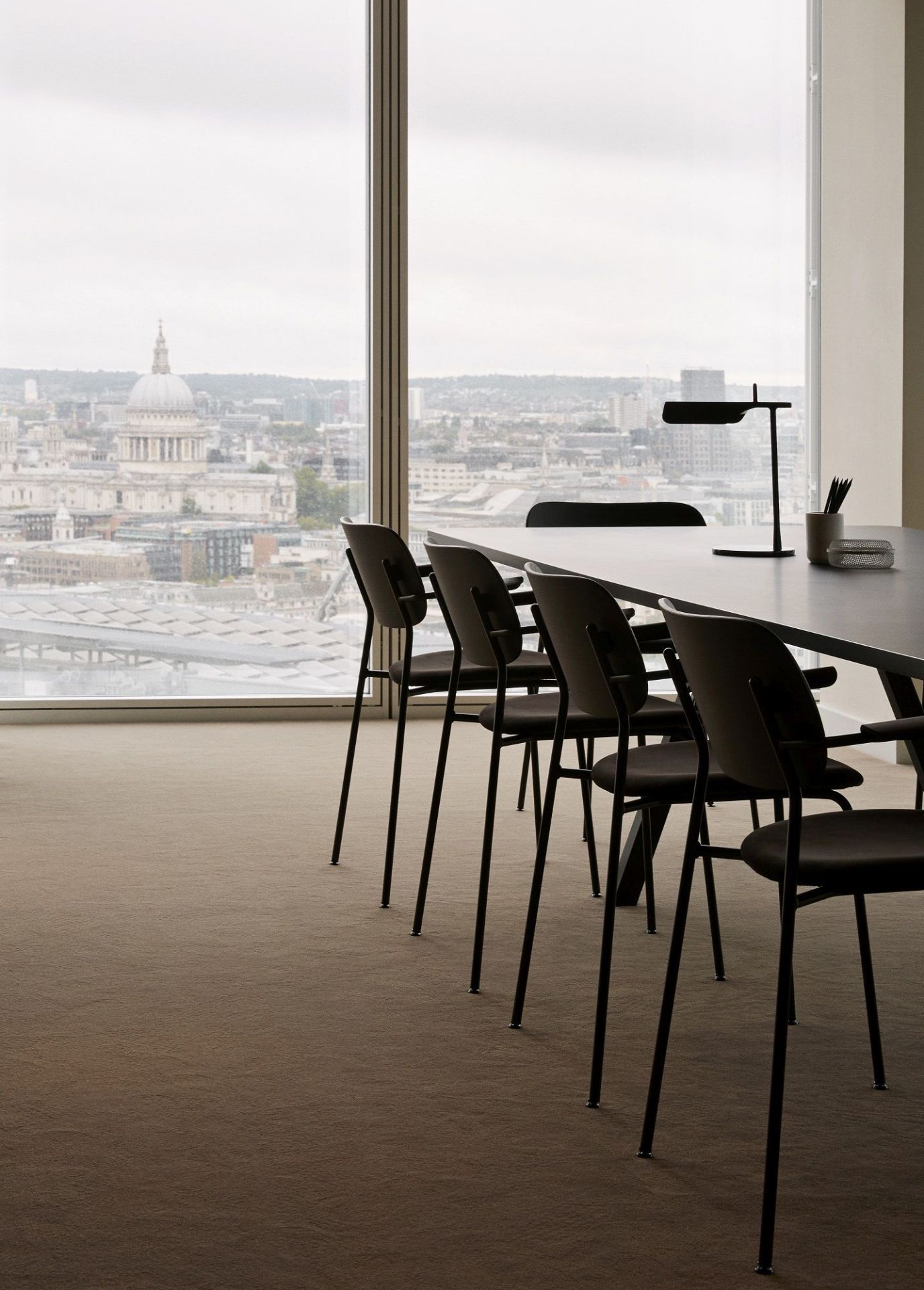 Reihe schwarzer Co Dining Chair Stühle von Audo Copenhagen an einem Konferenztisch mit Blick auf London.