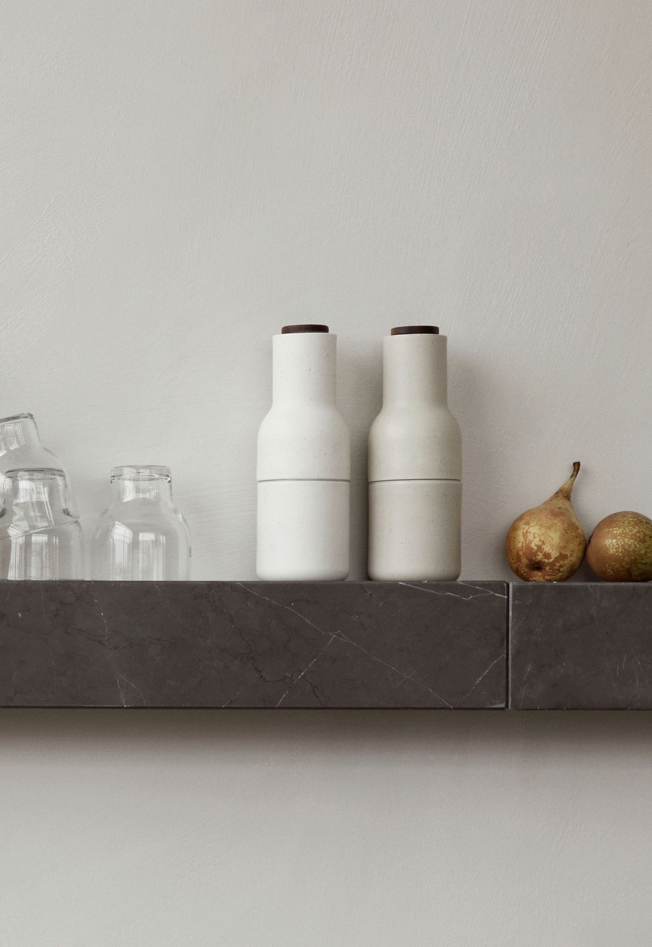 Audo Copenhagen Plinth Shelf Regal mit Gläsern und Birnen dekoriert, modernes Wandregal aus Marmor.
